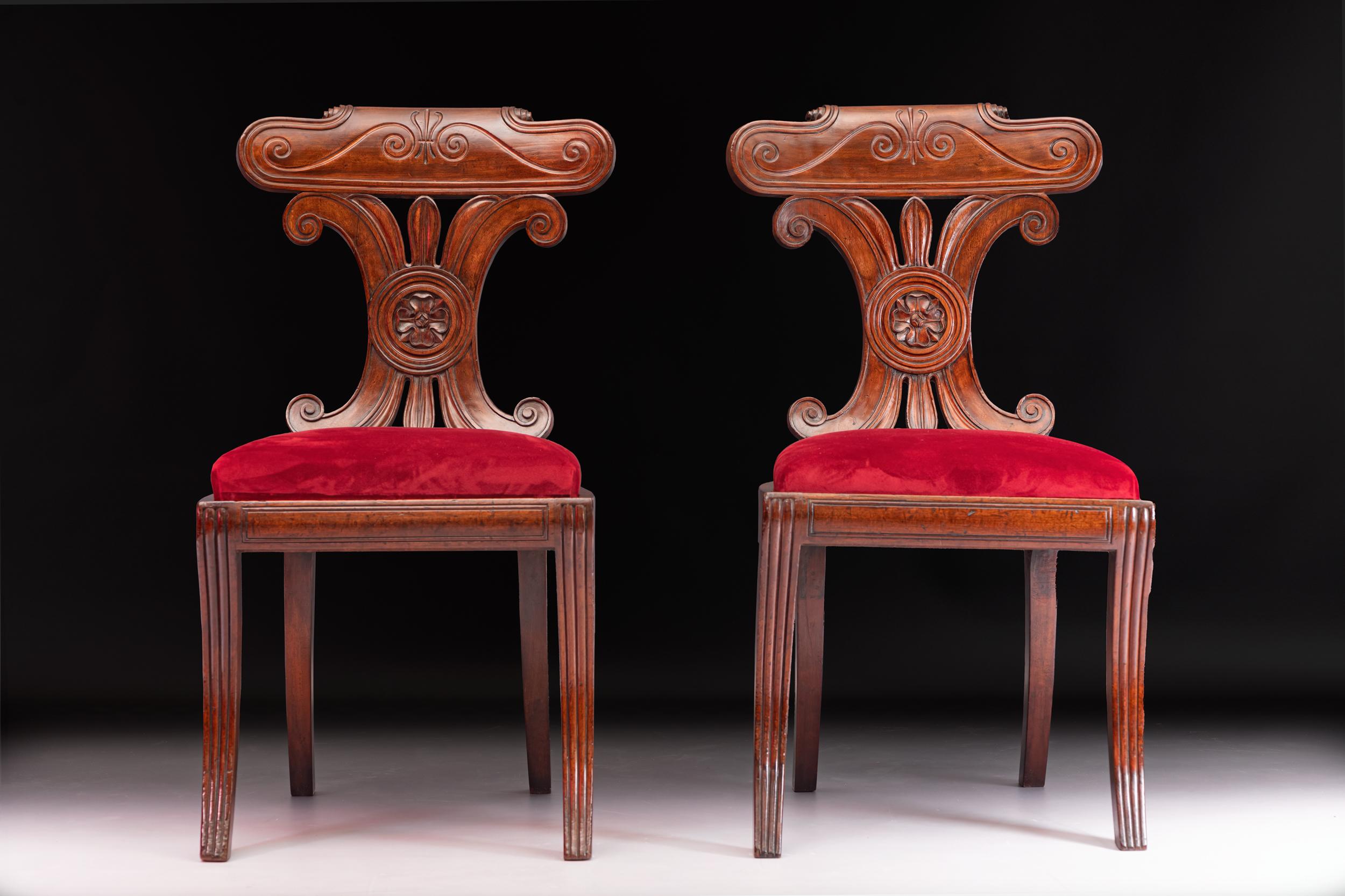 A very fine pair of Irish Regency mahogany Neo-Grecian hall chairs , with bowed tablet cresting, and conjoined c-scroll splat backs upholstered seats on ribbed sabre legs.

Circa 1820

Irish