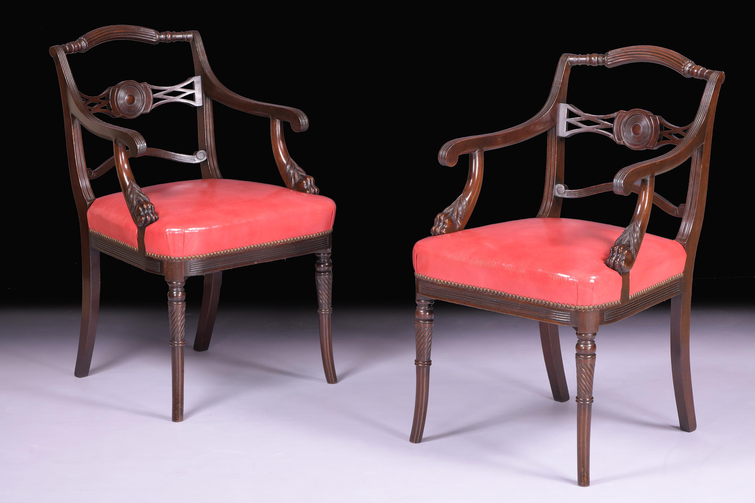 A superb pair of Irish Regency mahogany armchairs attributed to Mack, Williams and Gibton, the arched reeded crest rails above open frames with lattice-work back rails, each with arm supports terminating in carved paw feet, the seats upholstered in