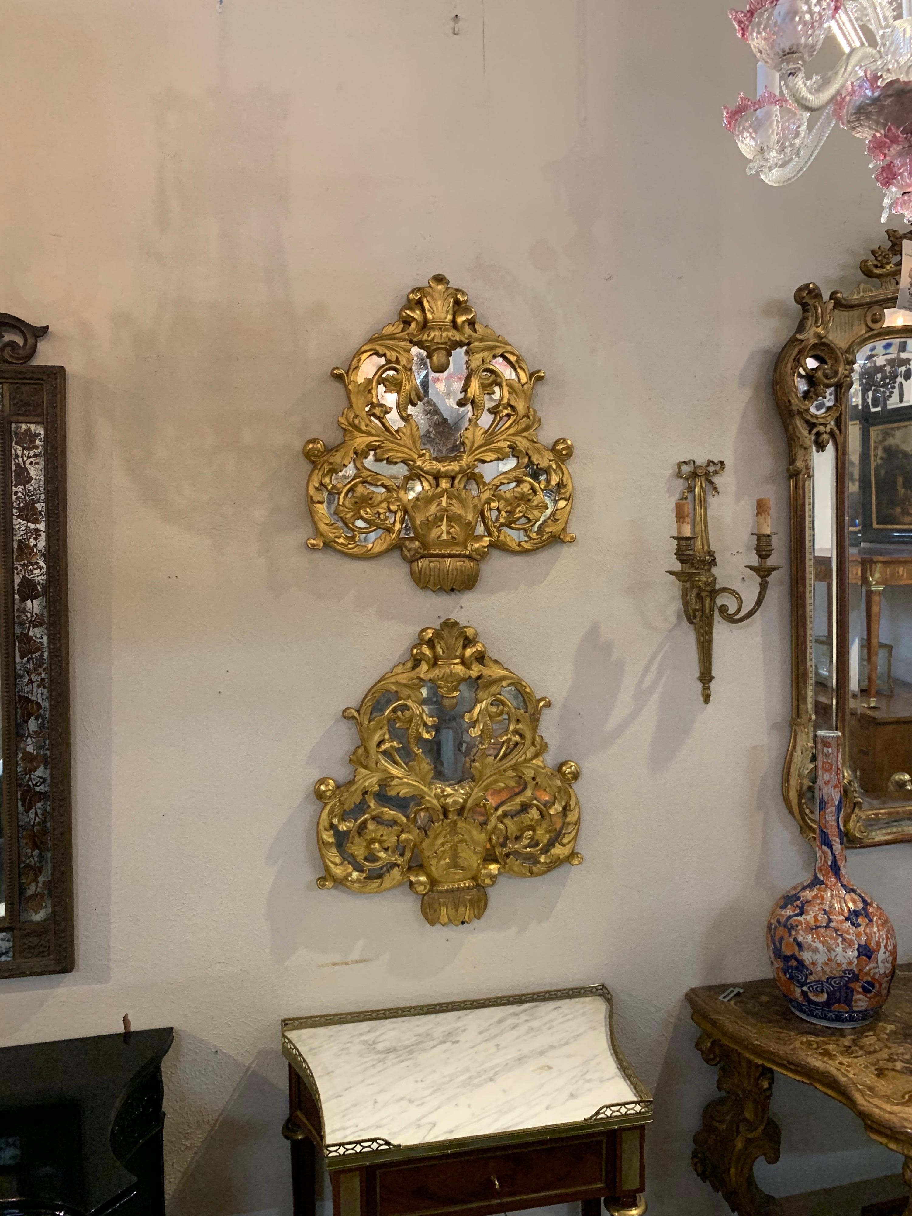 Decorative pair of early 19th century Italian carved and giltwood mirrors. Very fine gilt and carvings on these. Makes a gorgeous accessory!