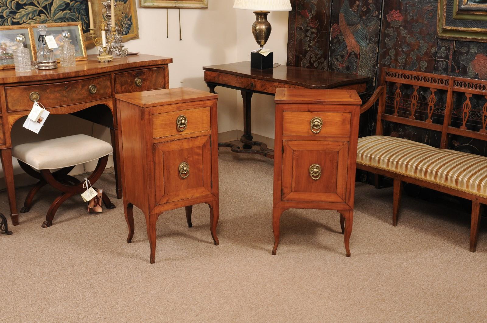 The pair of Italian early 19th century commodini in fruitwood each with one drawer and lower cabinet below with brass pulls terminating in cabriole legs.