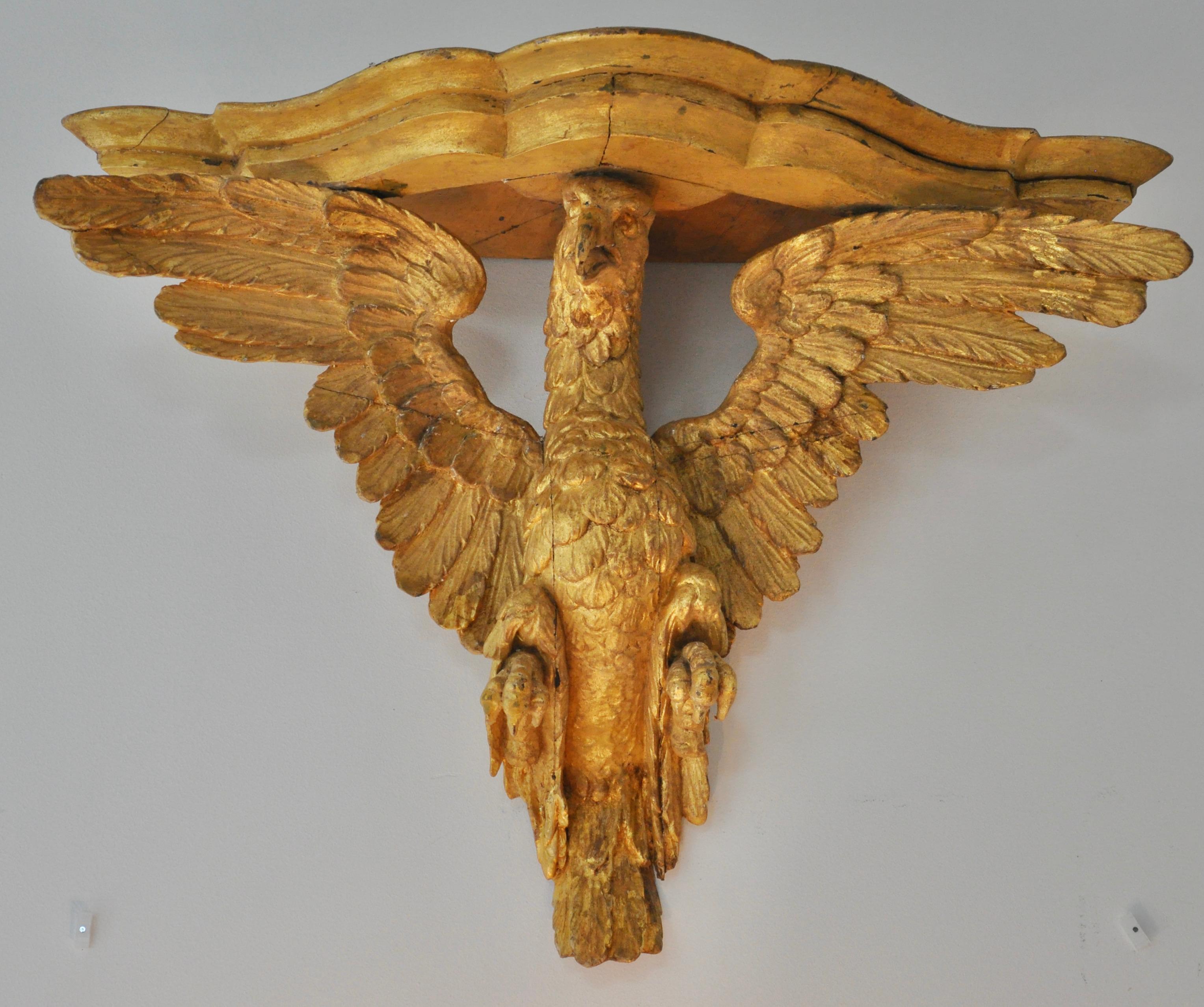 Pair of early carved and giltwood Italian eagle wall brackets. Realistically carved wooden eagles with original bracket shelves. Mostly original gilding, minor restorations. Good larger size.