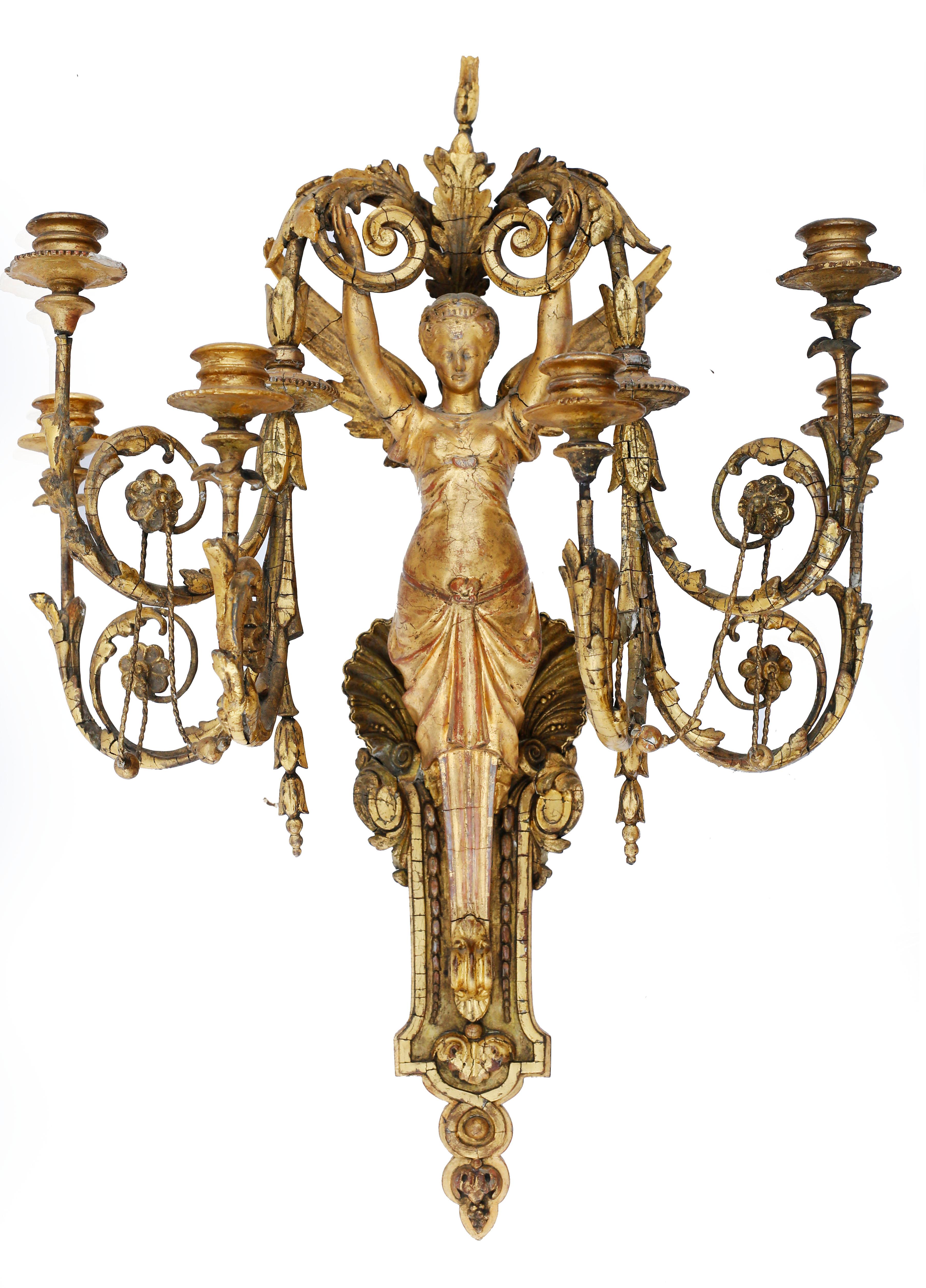 An exquisite pair of giltwood six-light wall sconces. The light is supported by the figure of a winged seraphim whose draped lower half melds into a molded bracket and acanthus pendant. The upper half of the bracket is decorated with a large scallop