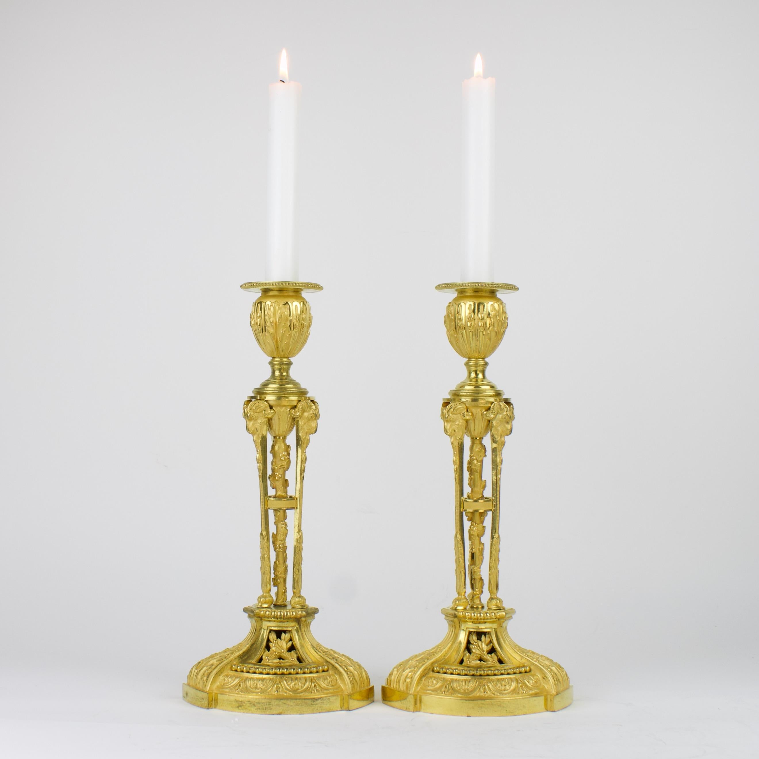 Excellent pair of Louis XVI gilt bronze candlesticks after a model by Etienne Martincourt (master 1762, died after 1791): 
Candelstick shaft à l'Athénienne consisting of three caryatids with rams' heads and hooves standing on a domed circular base