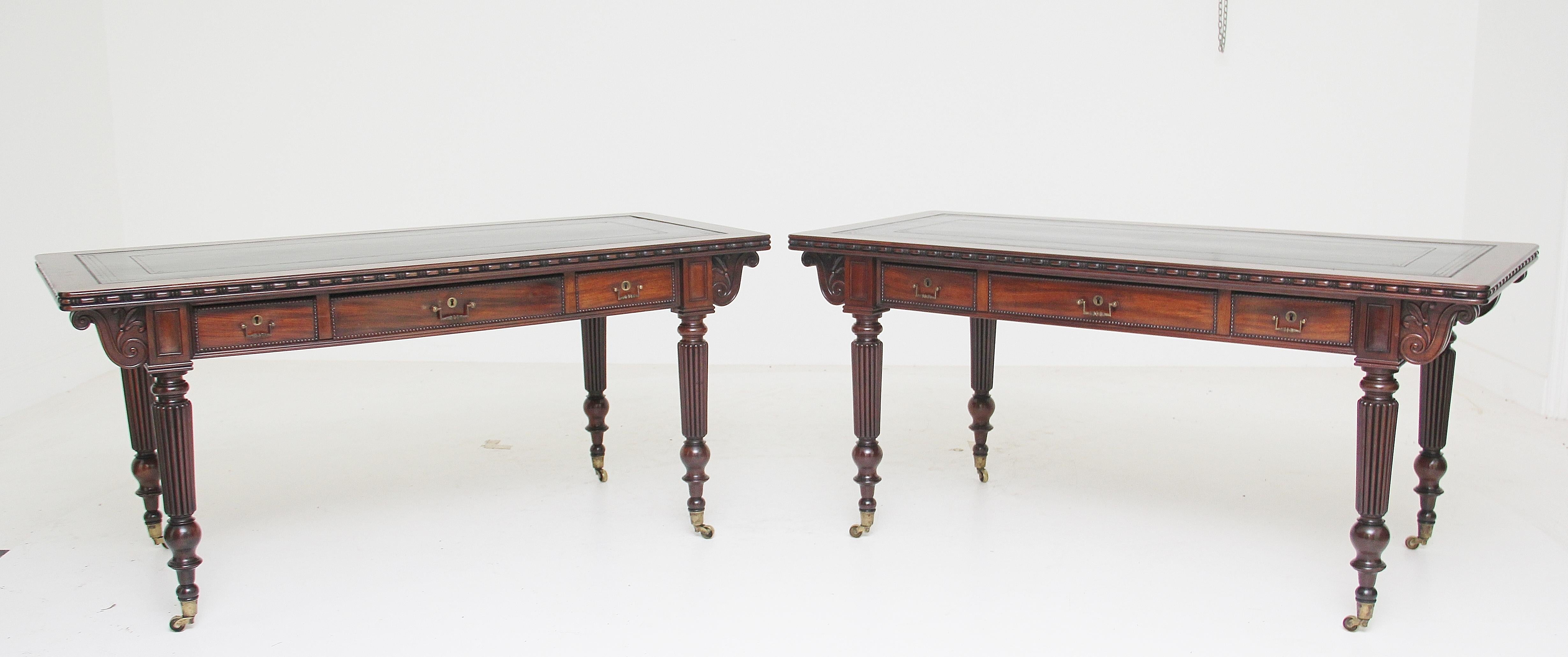 A pair of early 19th century mahogany library / writing tables of exhibition quality, the tops having a black leather writing surface decorated with gilt and blind tooling, with pullout / pull-out writing slides either end also with a black leather