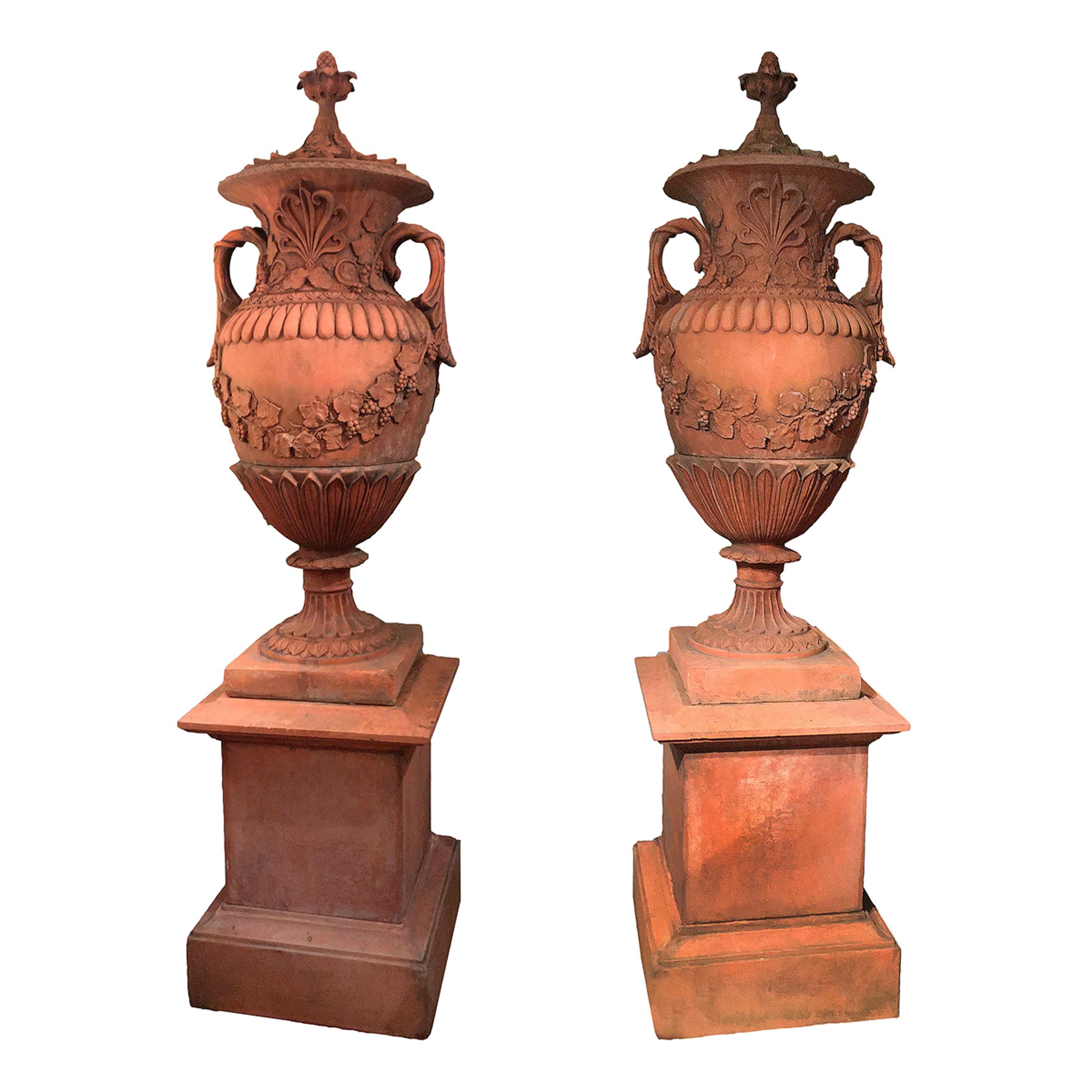 Paar neoklassizistische Terrakotta-Urnen und -Deckel des frühen 19. Jahrhunderts auf Sockeln