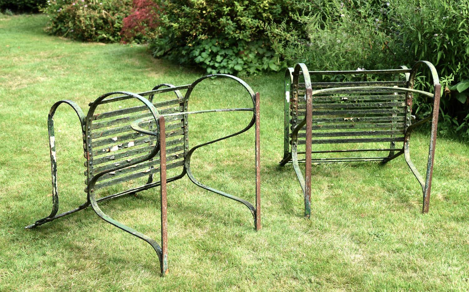 A fine and rare pair of English Regency period wrought iron garden armchairs, each with three strap back rails over a seat supported by 's' curved side frames and a bow-arched stretcher.
Showing a multitude of ancient coats of paint and many years