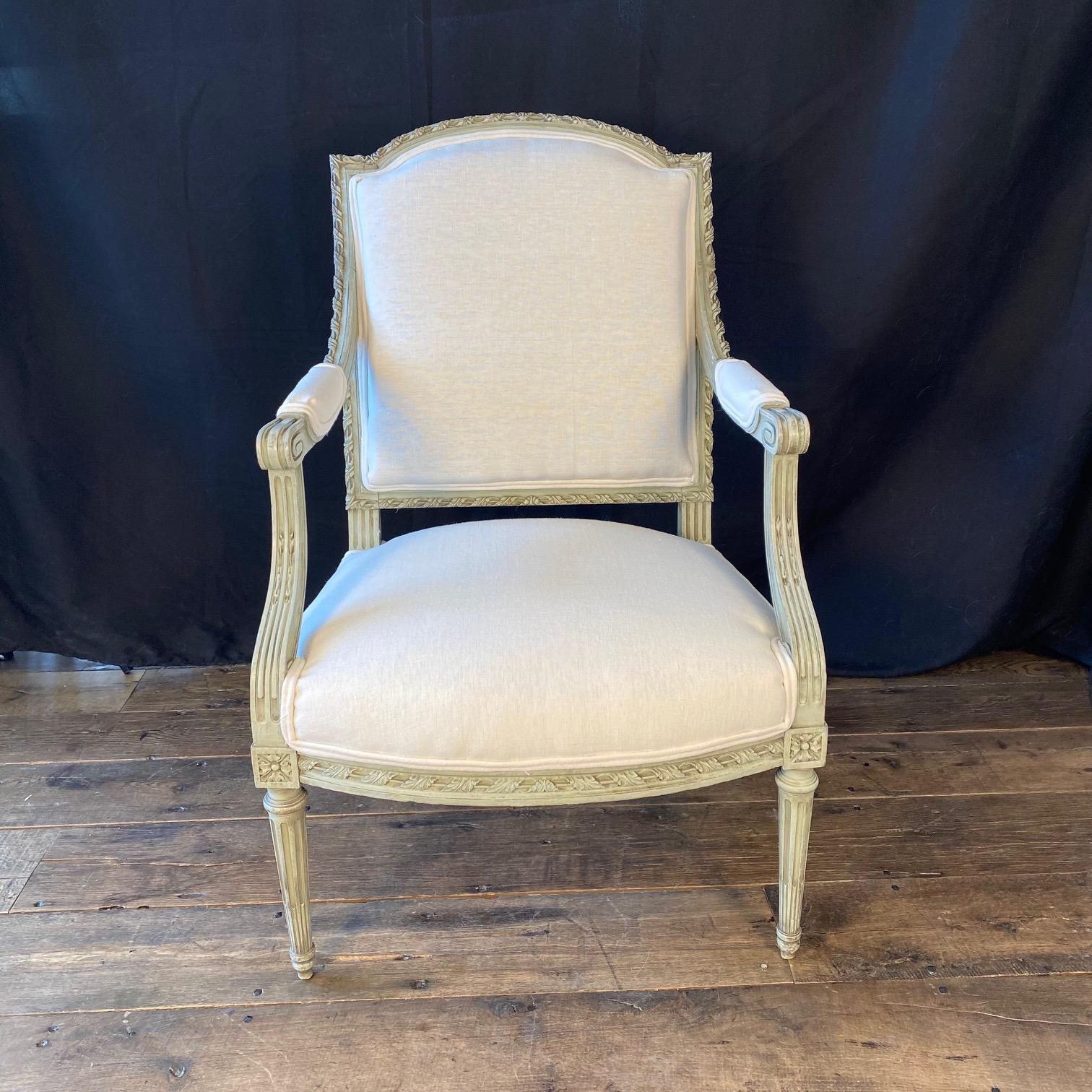 Pareja muy elegante de sillones o fauteuils franceses, pintados y bellamente tallados con mucho detalle. La pareja está pintada en un suave gris ostra pálido original, que resalta los bellos detalles tallados en todo el marco. Cada silla se ha