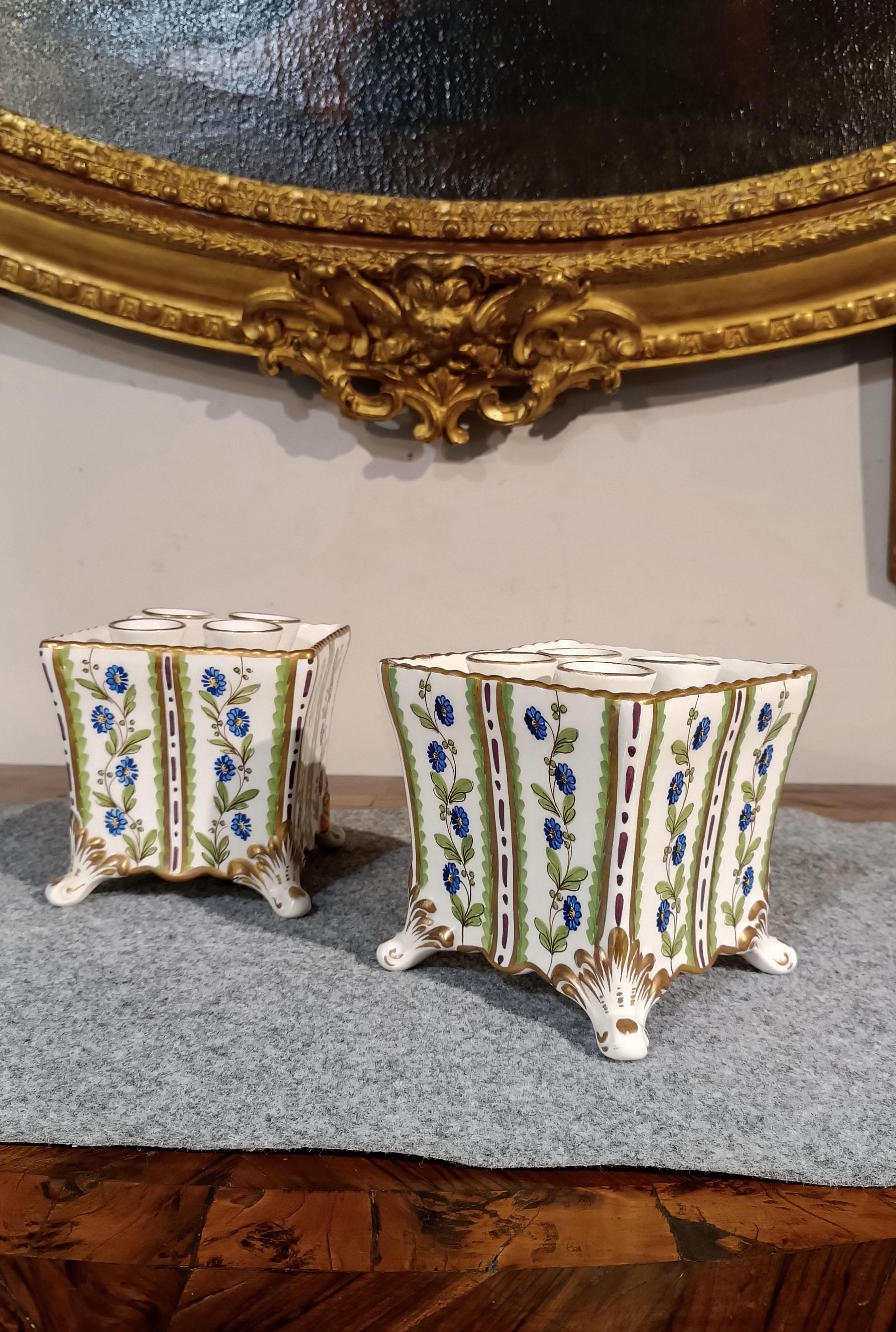 Beautiful pair of polychrome porcelain flower holders, quadrangular in shape with wavy feet and edges. The accurate and detailed decoration, with golden motifs and linear and vegetal paintings, gives them a touch of class and beauty. The upper part