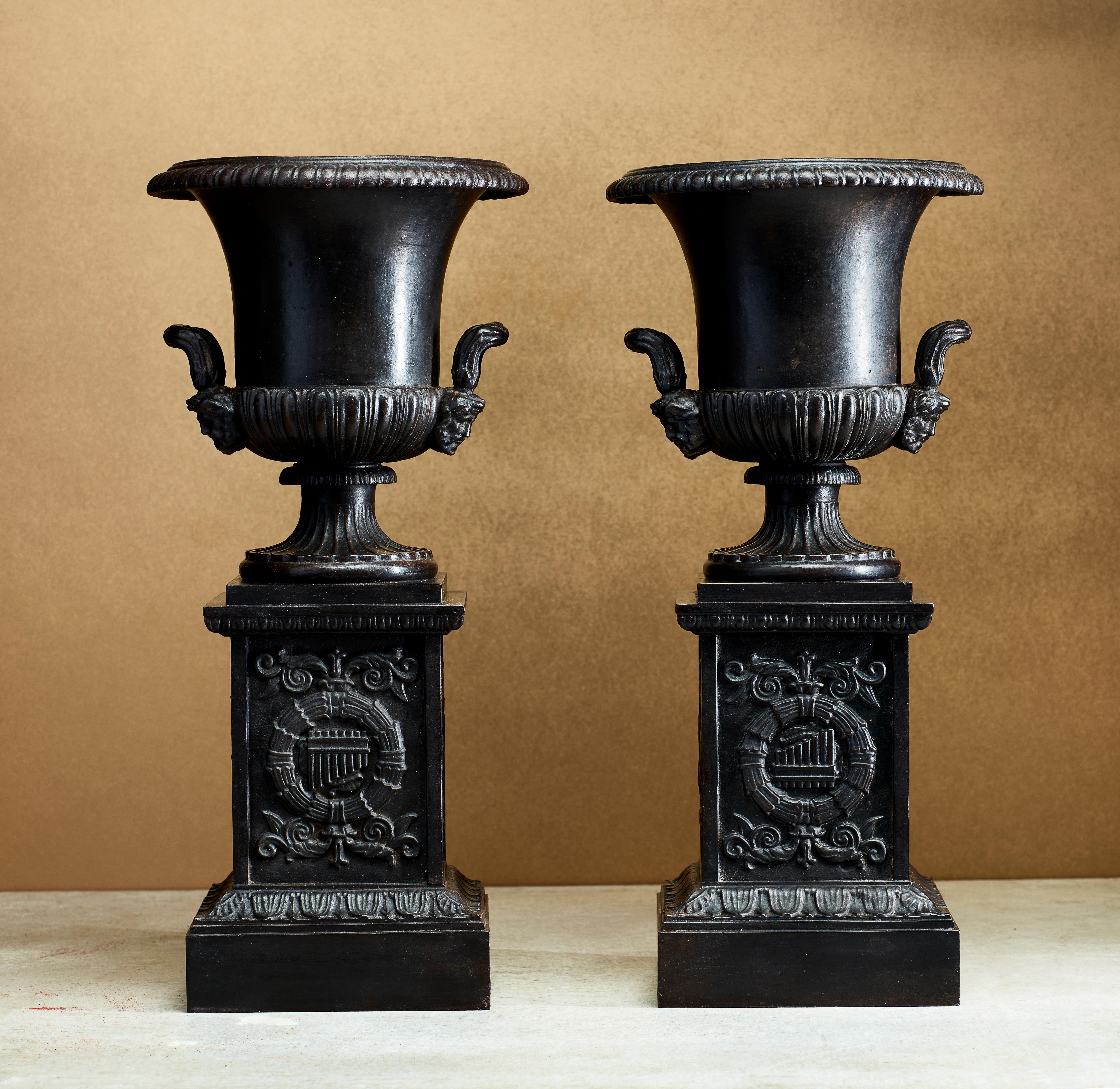 A beautiful pair of cast iron vases (urns) on pedestal, attributed to the Royal Prussian Iron Foundries in Gleiwitz. This pair is modeled most likely after or inspired by an ancient Greek or Roman vase, one of the most important and best-known