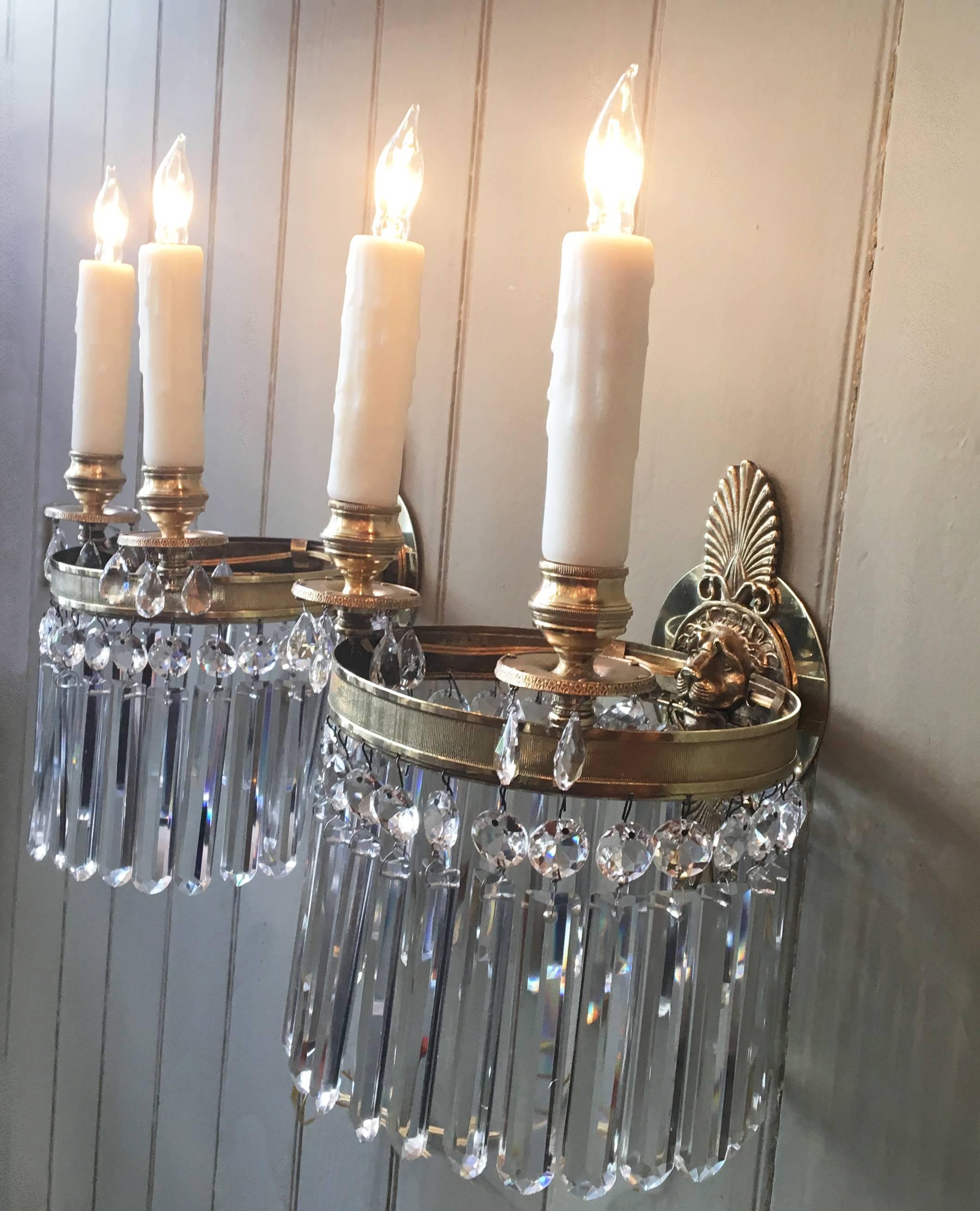 This lovely pair of early 19th century English Regency lion head and Athenian leaf sconces are made of brass and crystal. They are double armed, rewired, and electrified.