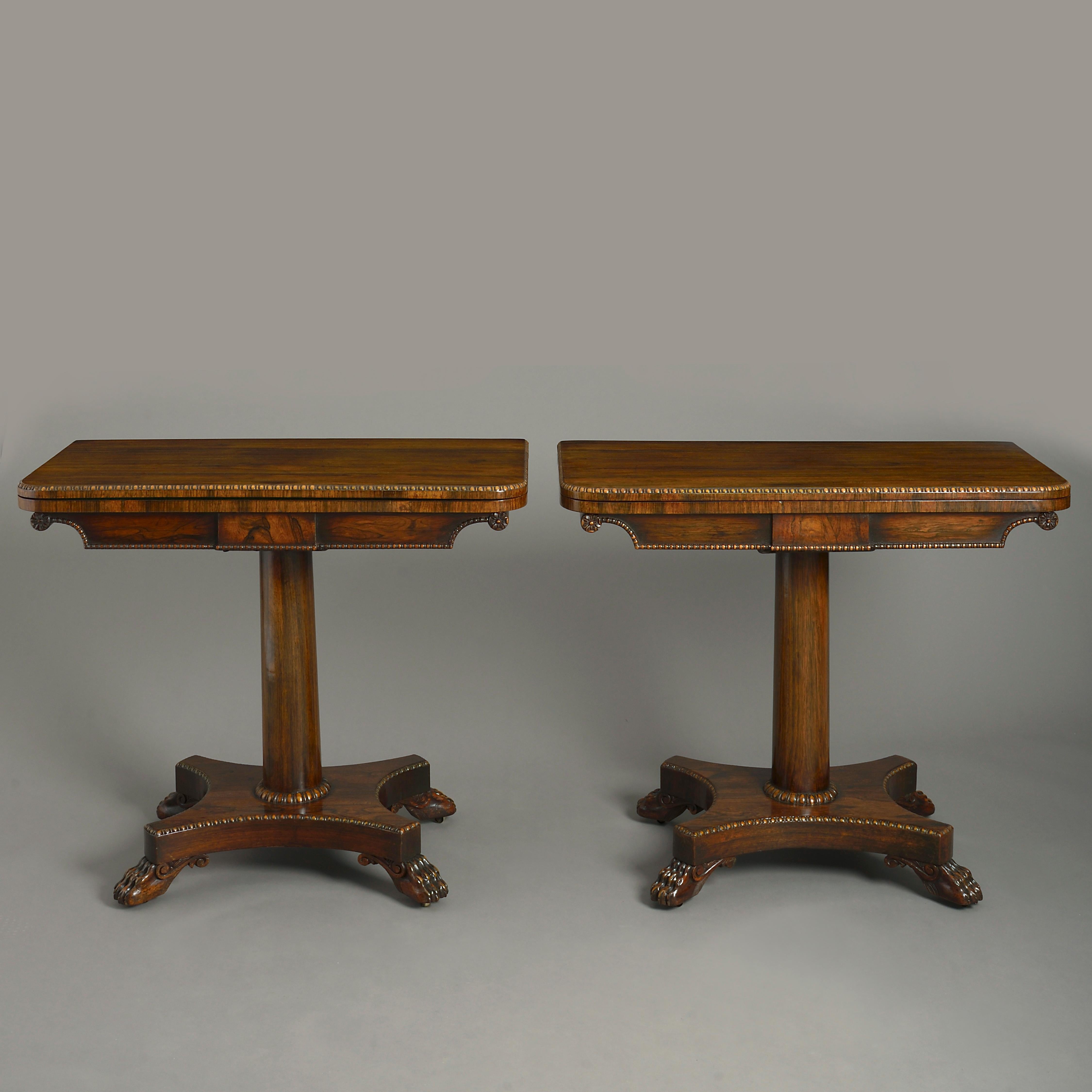 A pair of early 19th century Regency period rosewood card tables, each having a swivel top with carved egg and dart motif beading, opening to reveal a recess and green baize underside, raised upon a turned column stem above a concave plinth with