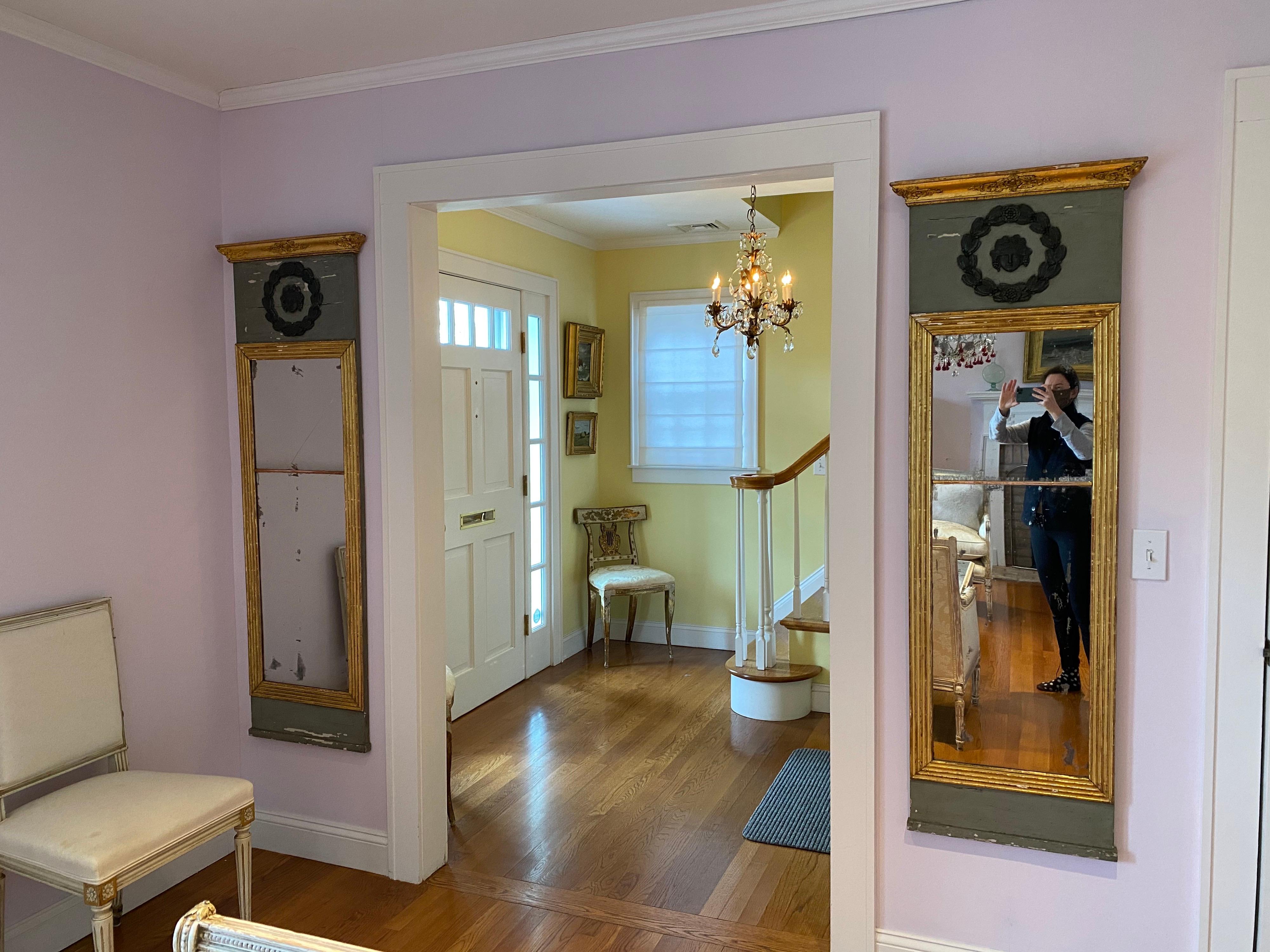 Pair of Early 19th Century Swedish Neoclassical painted pier mirrors.
Stunning long, narrow pair of mirrors in a attractive tone on tone green painted finish and gilded on the crown and frame of mirrors. Center medallion of the head of Bacchus
