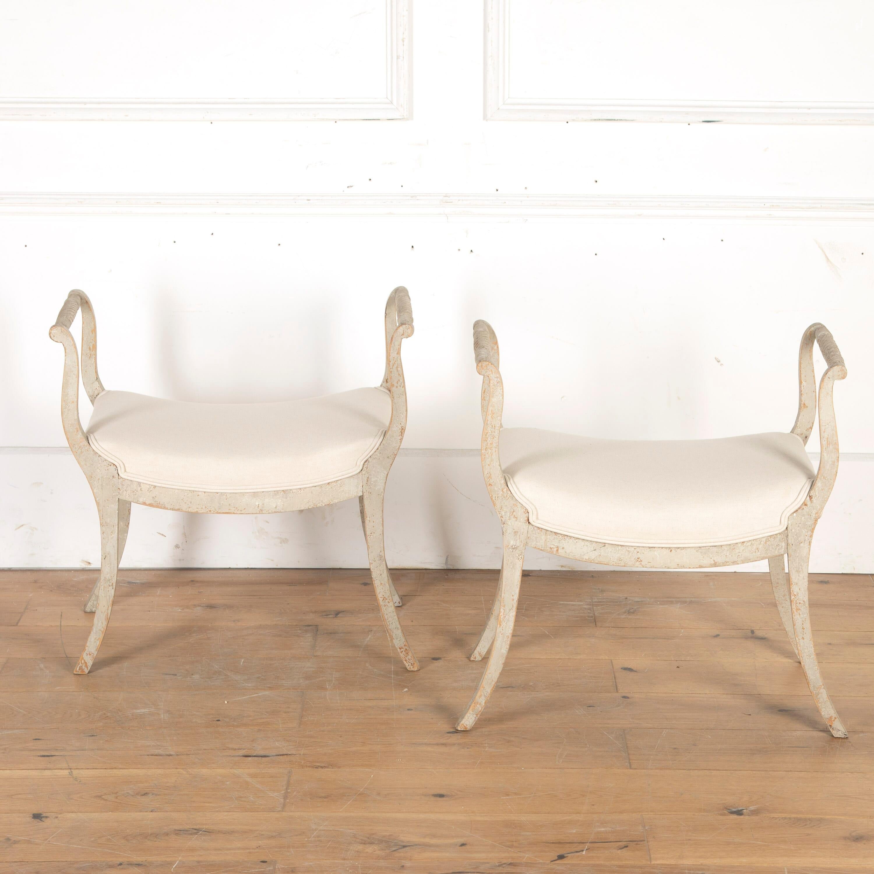 Pretty pair of Swedish Empire early 19th Century stools, circa 1820.

With lovely carved detailing to the armrest top rails and resting on elegant sabre legs. 

These stools have been repainted and stabilised for everyday use and the seats have