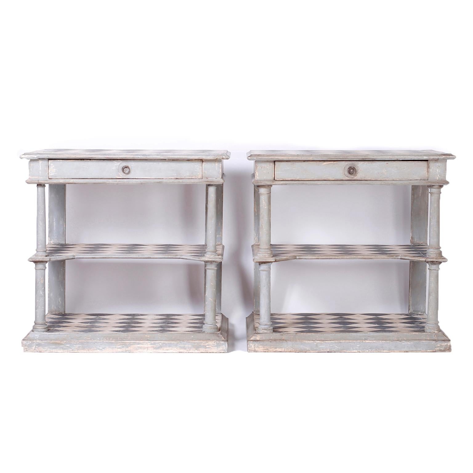 Pair of handmade antique Italian servers or consoles with three tiers decorated with harlequin designs on the tops. The cases with one drawer and turned supports are painted with Classic continental putty grey over gesso now aged to perfection.