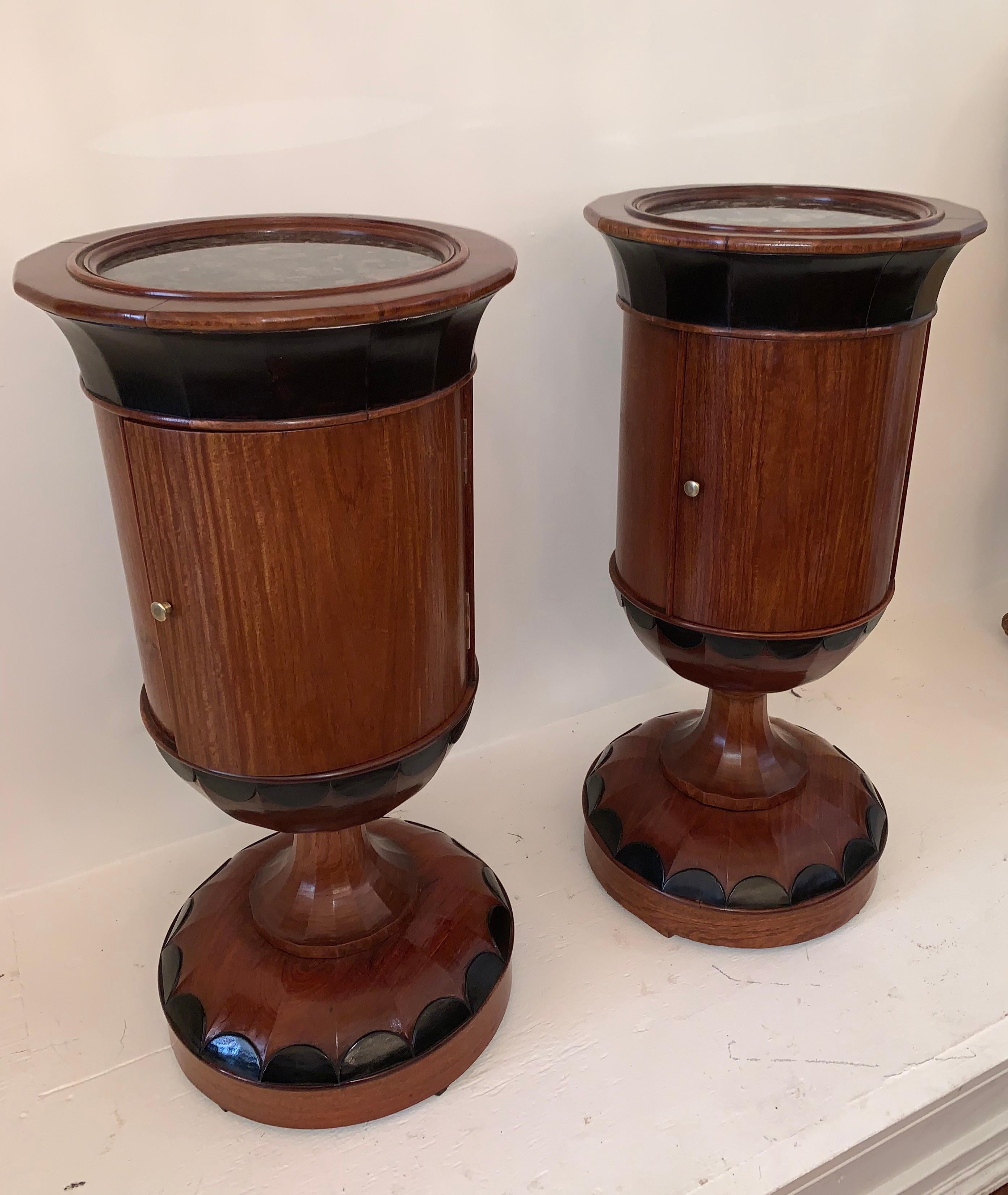 These unusual Biedermeier pedestals have a inset marble top. The column cabinets sit on a Hexadecagon that is highly figured veneer pedestal with ebonized highlights, creating a sophisticated contrast of color against the dark Walnut. The base, stem