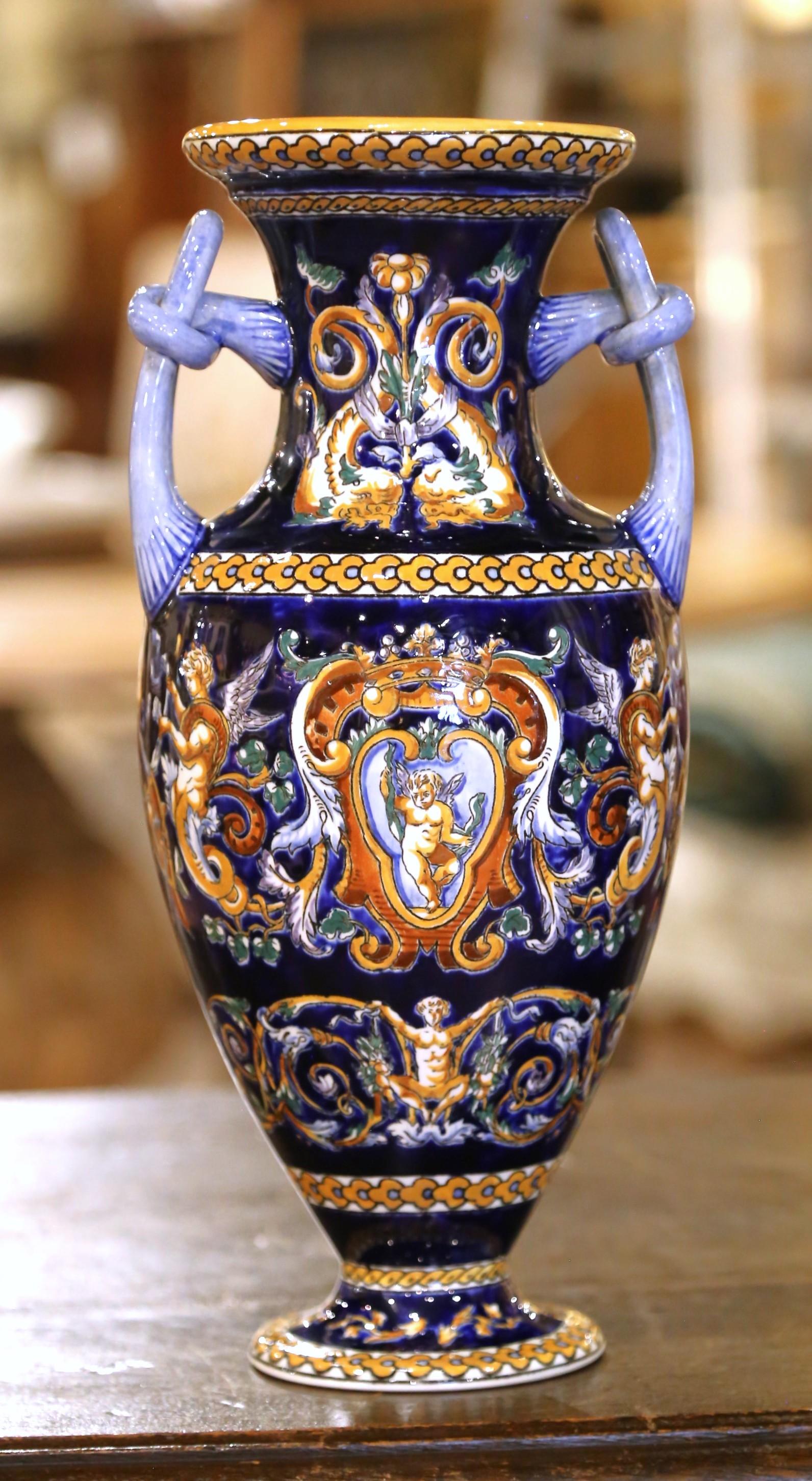 This elegant pair of antique faience vases was crafted by the Faïencerie de Gien in France circa 1920 and is marked “Gien France décoré à la main” on the base. Hand-painted in rich cobalt blue, ochre, and ivory tones, the vases are decorated in the