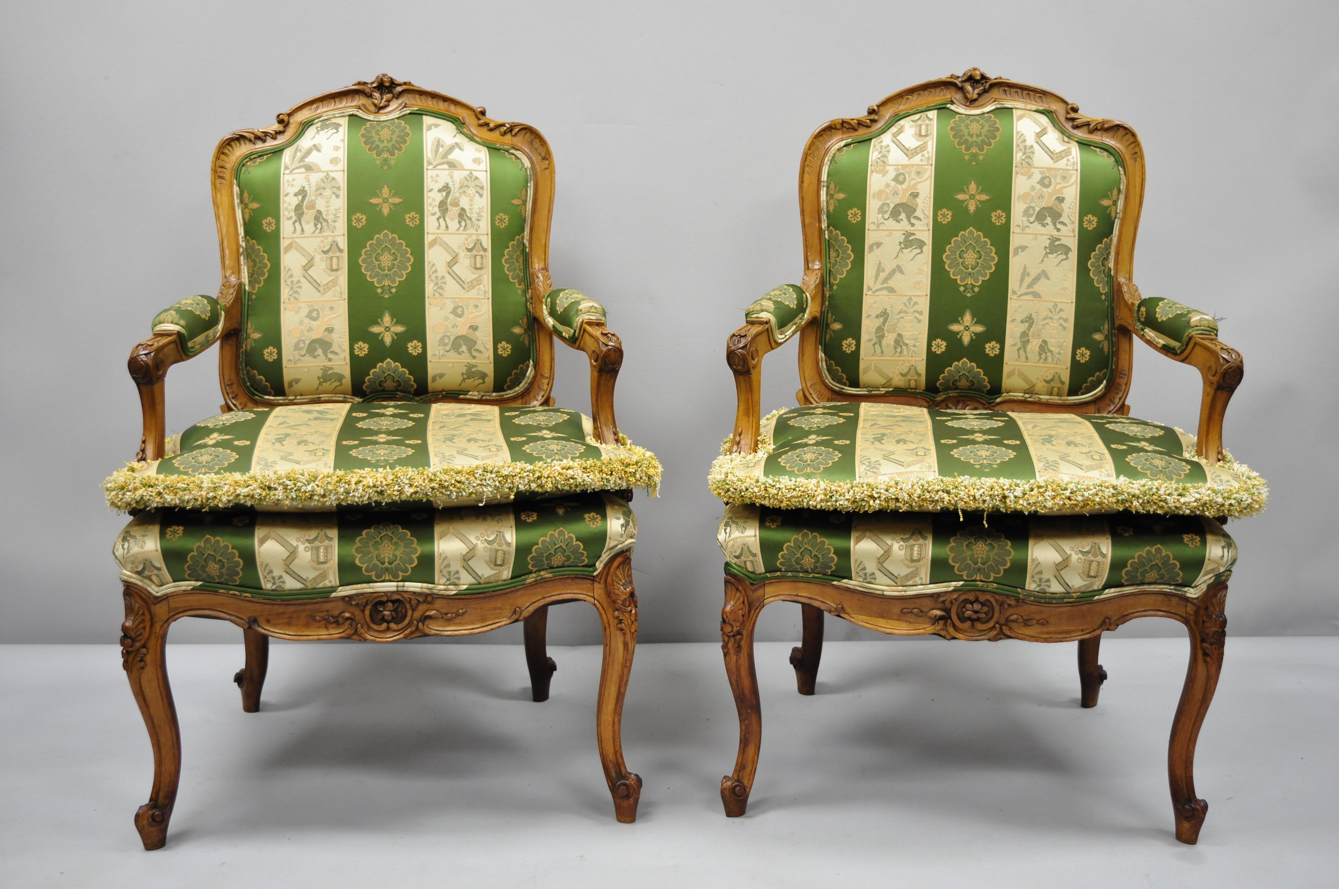 Pair of early 20th century French Louis XV style green and gold walnut fauteuils armchairs. Item features green and gold silk fabric, loose pillow cushions, solid wood frame, upholstered armrests, finely carved details, cabriole legs, quality
