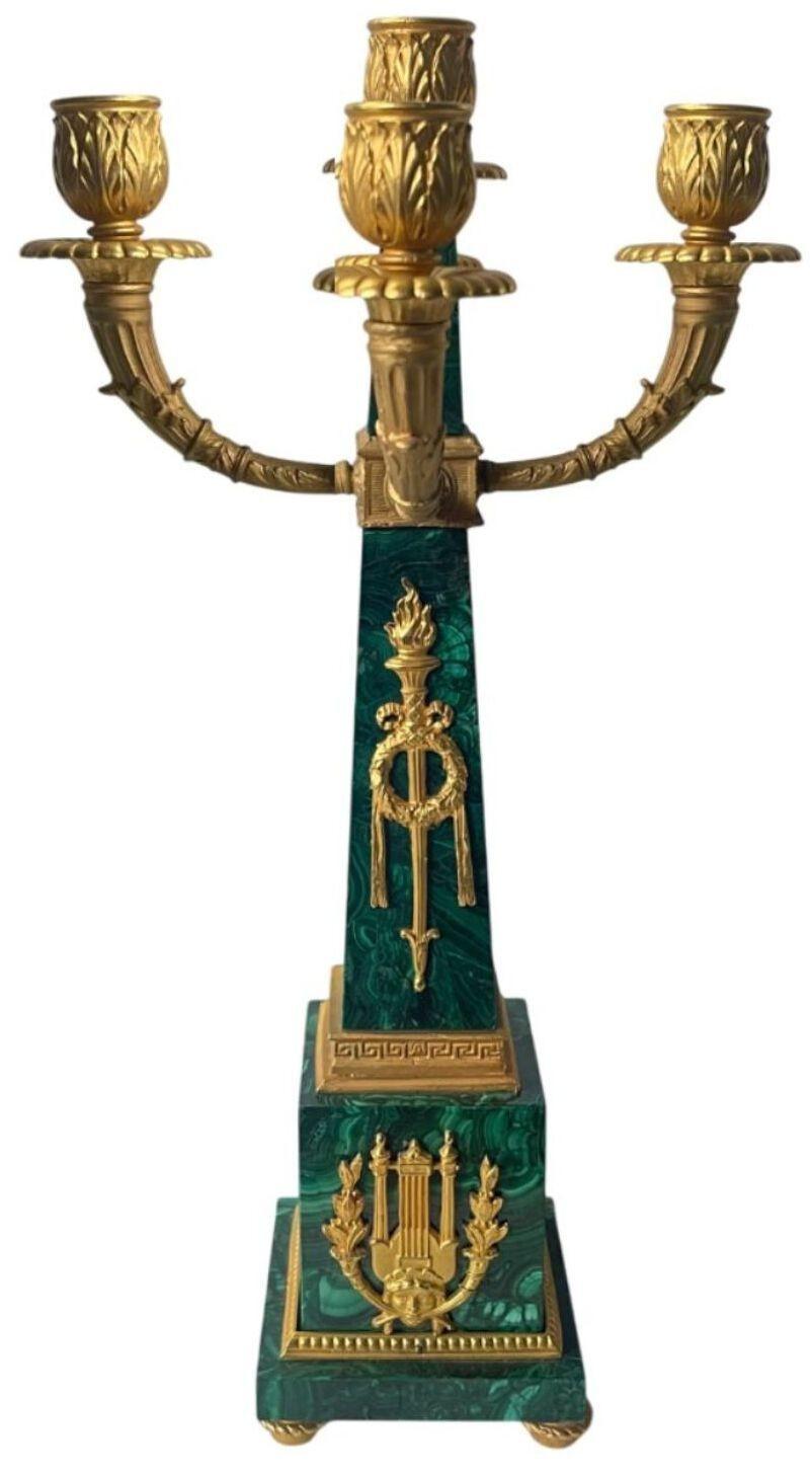 Exquisita pareja de candelabros franceses de principios del siglo XX, elaborados con rica malaquita y adornados con detalles de bronce dorado finamente fundido. Cada candelabro presenta brazos elegantemente ondulados, diseñados para albergar varias