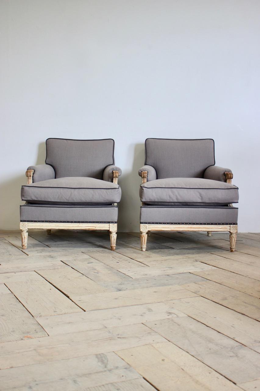 A very elegant pair of early 20th century French painted armchairs retaining the original paint, in the Louis XVI taste, having been reupholstered by us in a grey linen , with contrast piping and a feather cushions. 
Measurements: 48cm High (floor