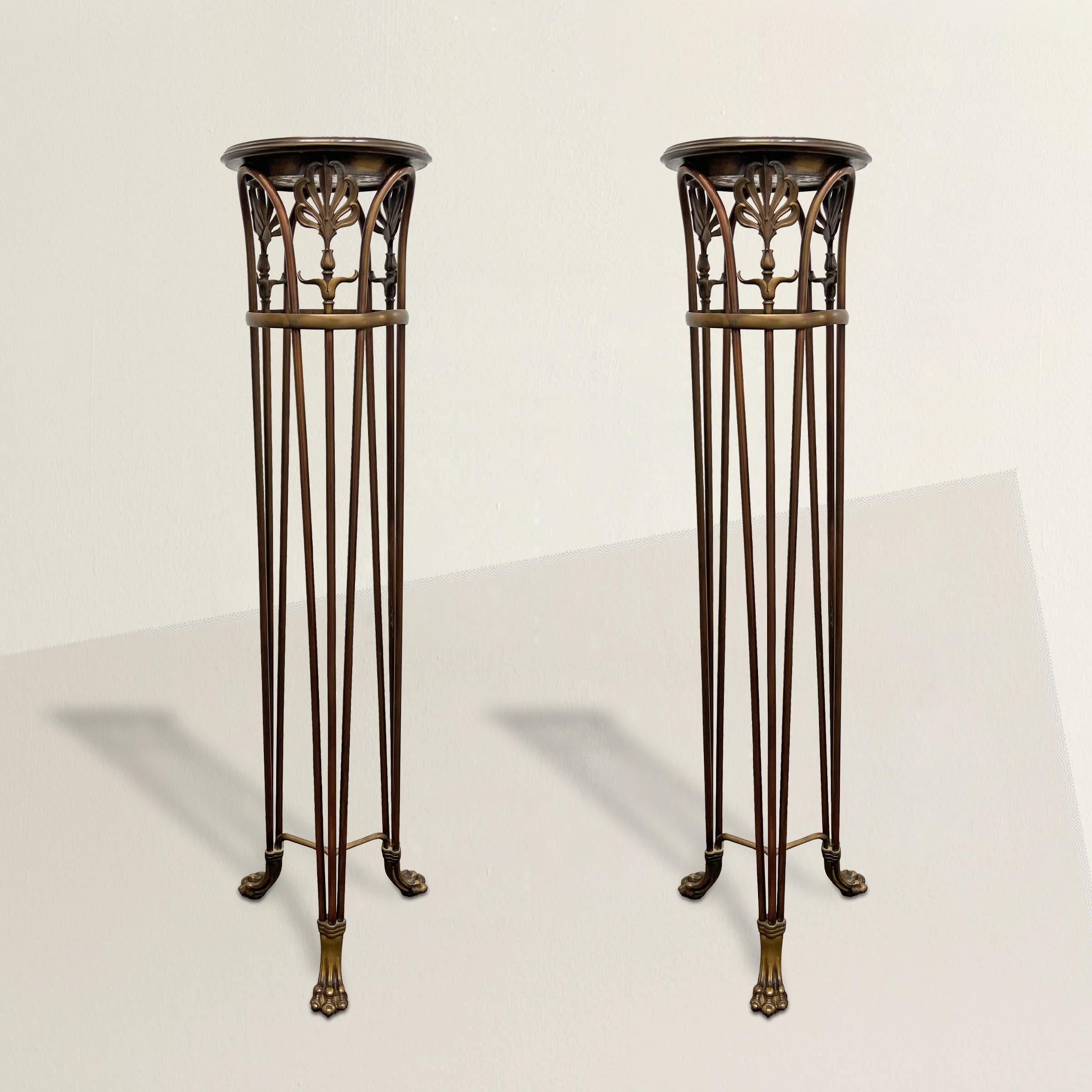 Indulge in the timeless elegance of this extraordinary pair of early 20th century American Beaux-Arts bronze plant stands by famed American foundry, Gorham, which effortlessly transform into pedestals for your cherished objet d'art. Crafted with