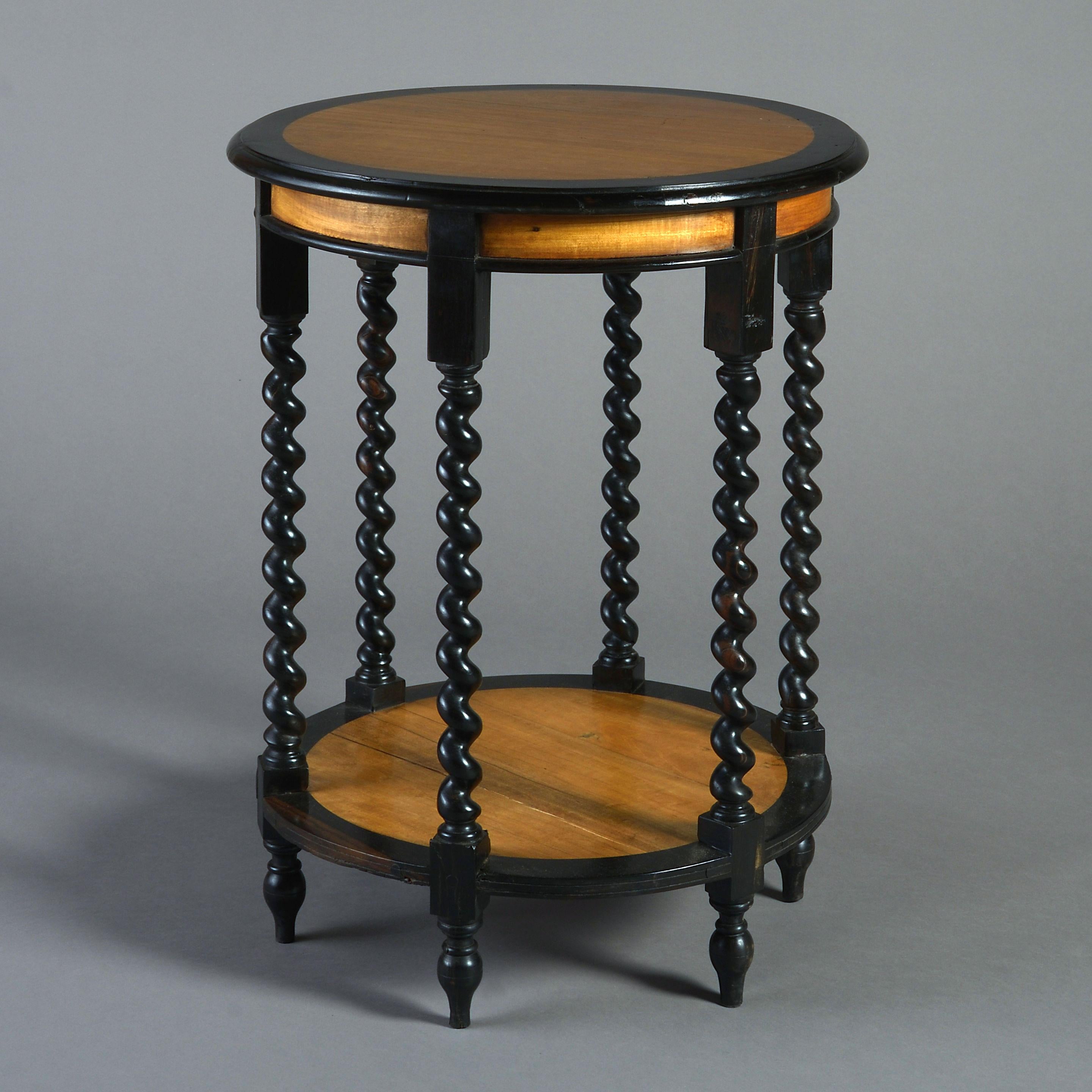 A pair of end tables of barrel form, having circular tops and bases of sandalwood, having ebony borders and barley twist supports.