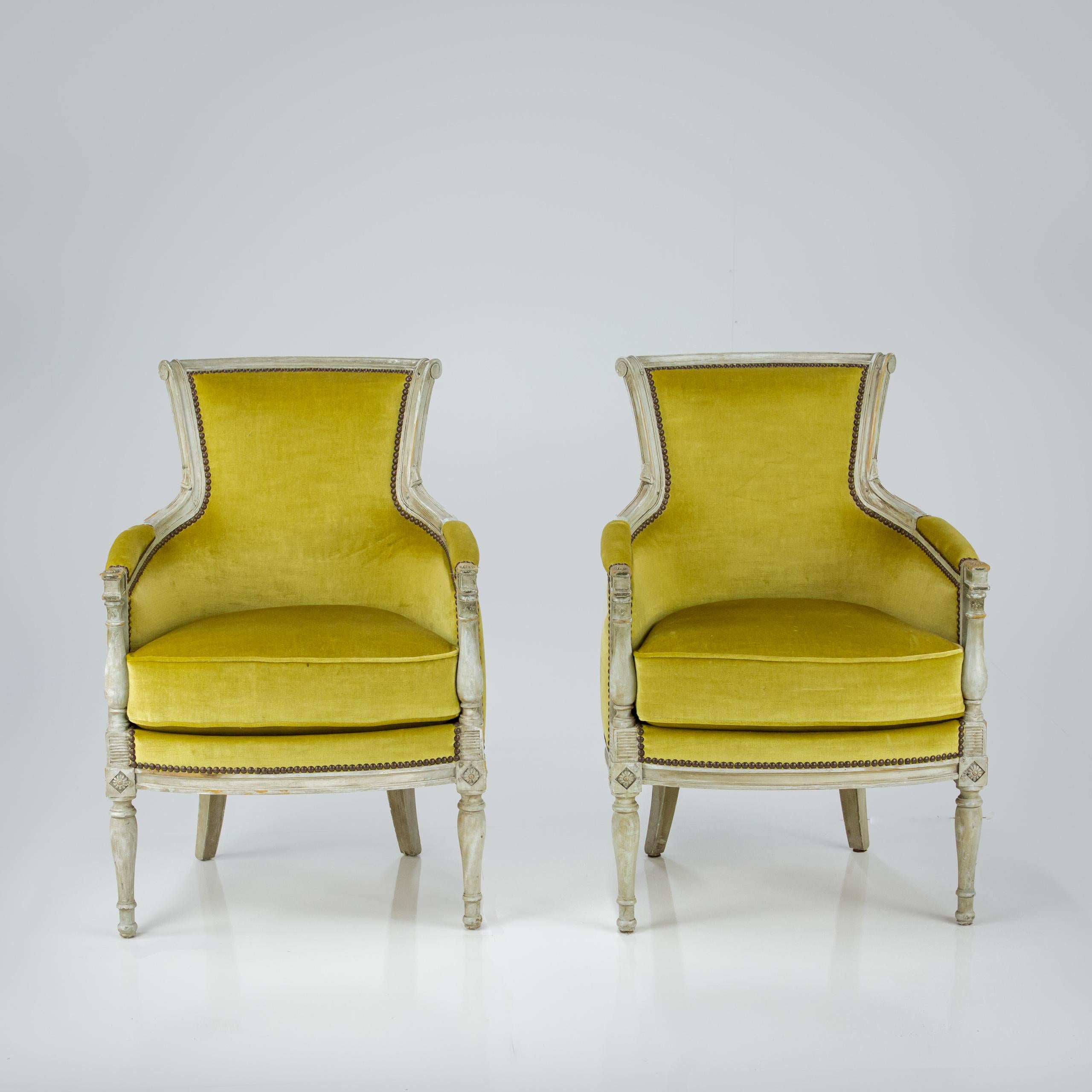 Early 20th Century pair of Bergere Armchairs. understated carved detail on the frames. Recently reupholstered in mustard velvet (some very minor blemishes). Historical cream painted finish. Seat Height 50cm France Circa 1920.