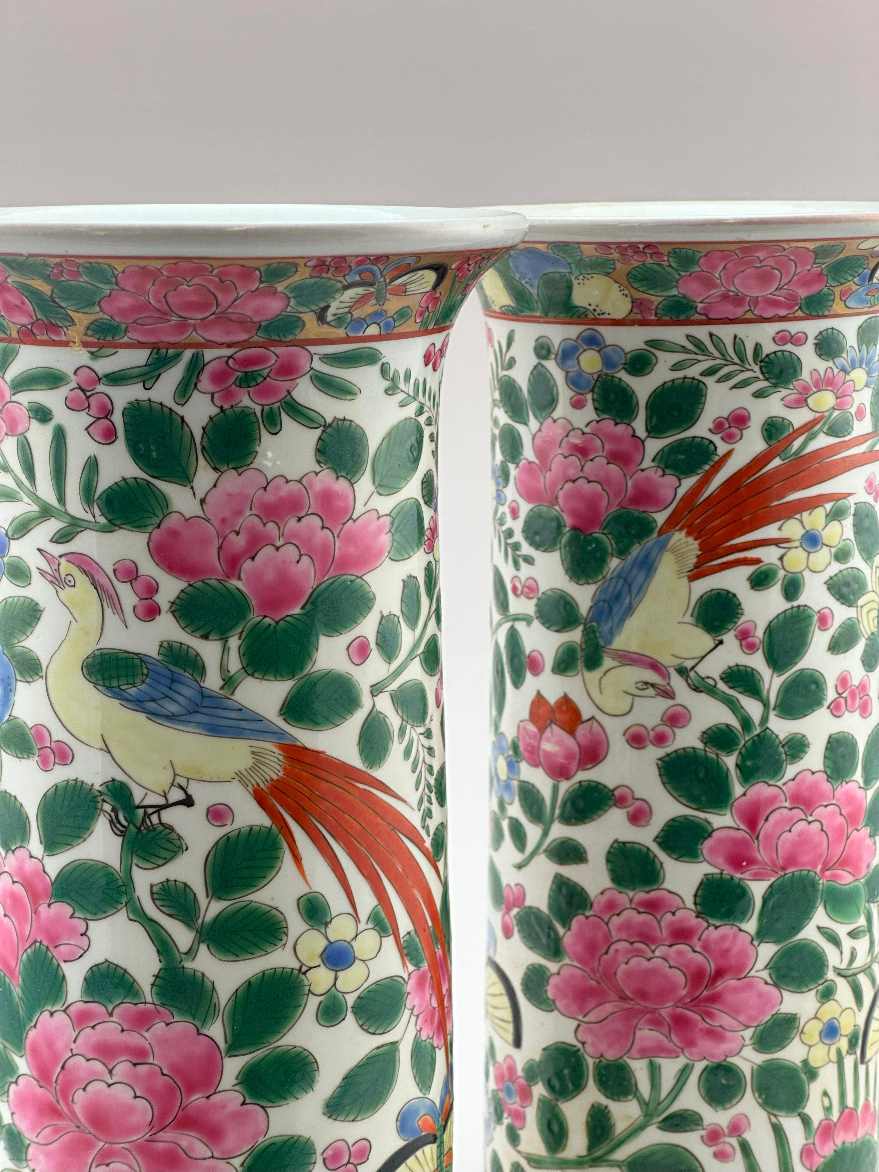 This pair of Chinese Export porcelain vases, dating to the early 20th century, is finely hand-decorated in the Famille Rose palette, a celebrated colour tradition within Qing dynasty porcelain. Each spill vase features a vibrantly enamelled tableau: