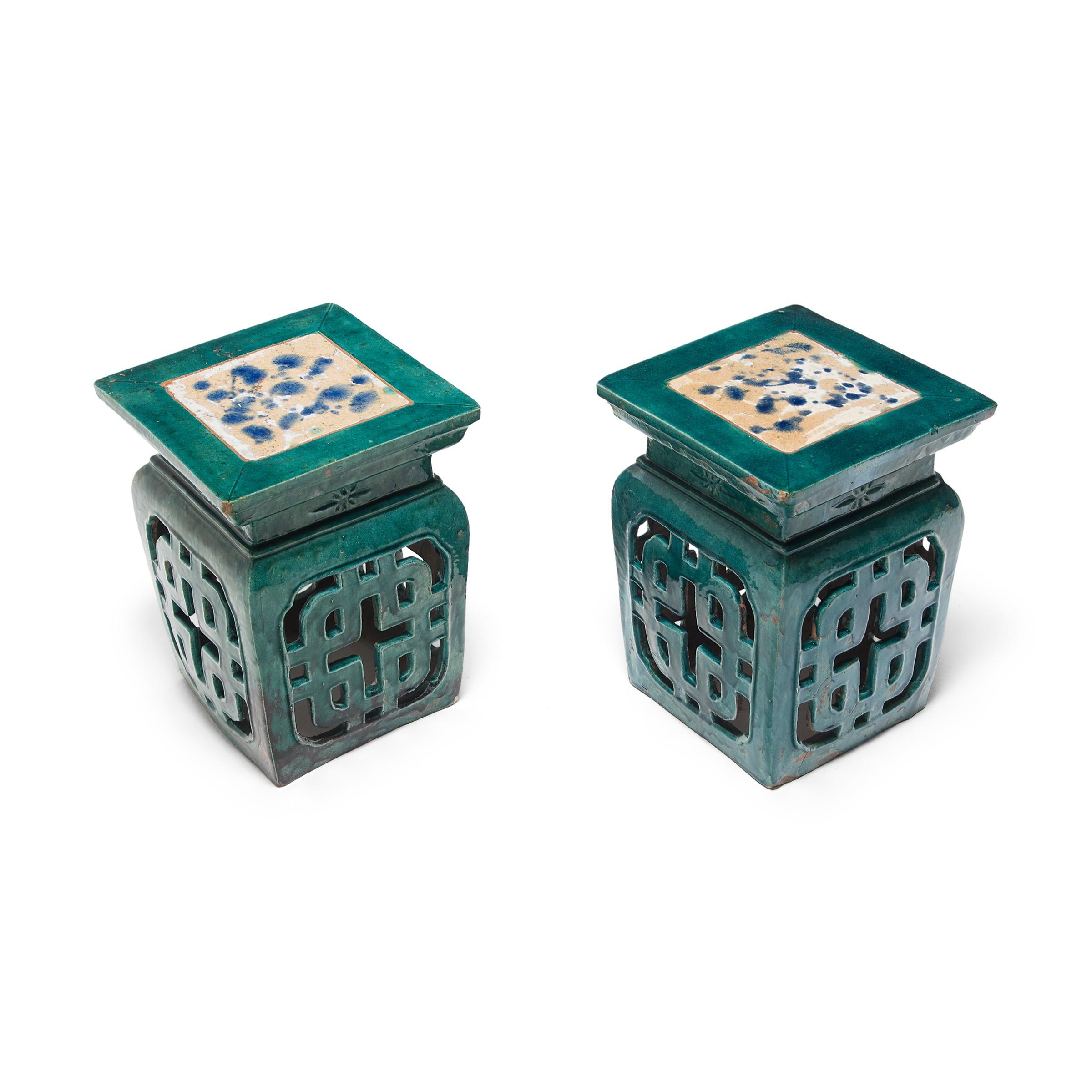 These early 20th century ceramic garden stools deviate from the traditional drum form with their angular shape and latticed sides. The stools instead borrow design elements from the Ming dynasty feng deng, a wooden stool featuring a square top and a