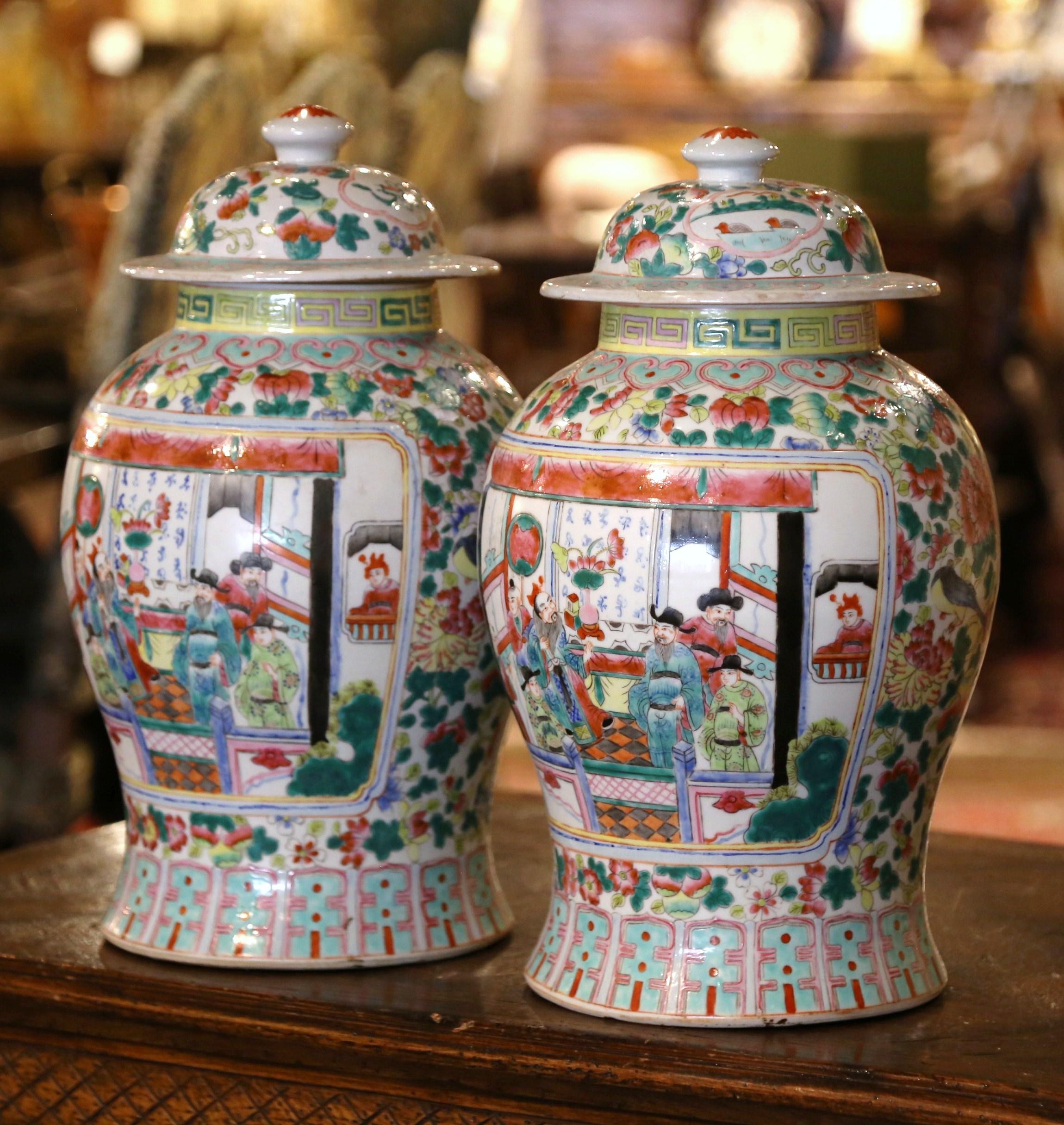 Decorate a console or mantle with this colorful pair of antique porcelain ginger jars. Created in China, circa 1920, each vase with tapered body and flared base, is decorated with hand painted figural scenes medallions, and further embellished with