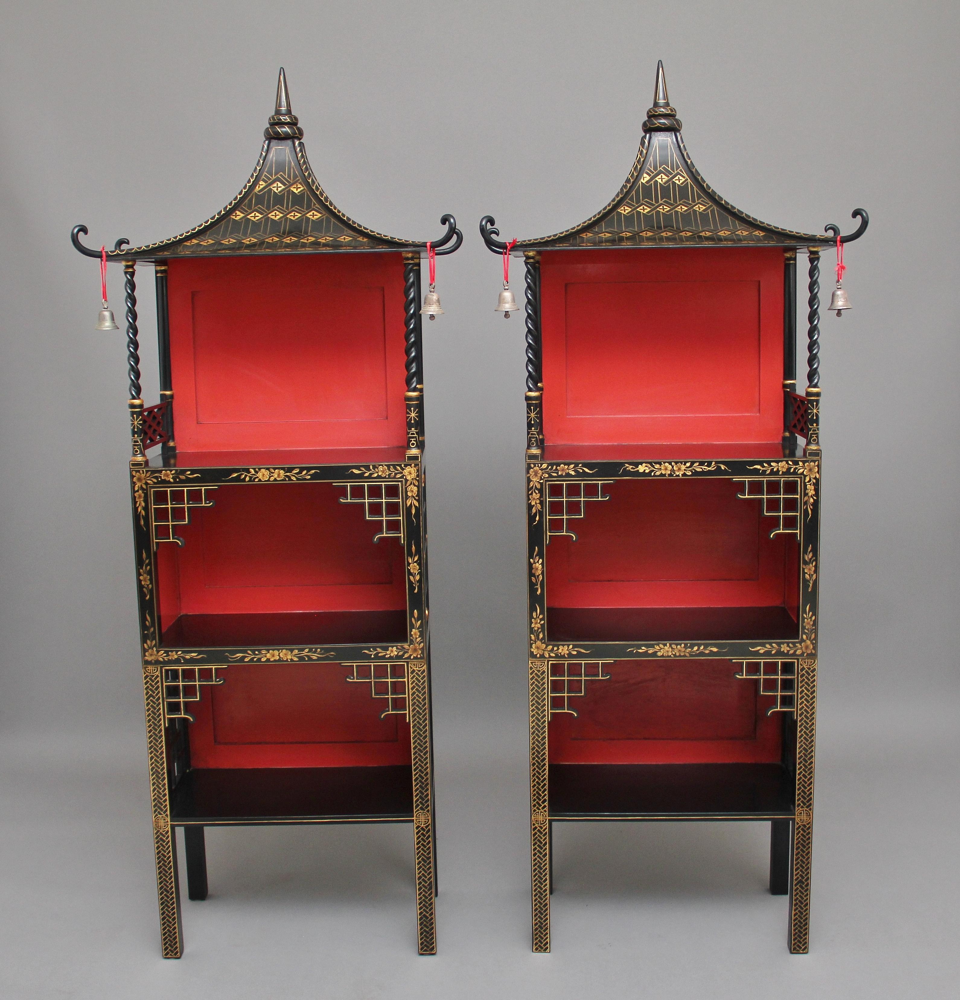 A fabulous and rare pair of early 20th century chinoiserie open cabinets in the 18th century Chinese style, the black lacquered cabinets with gilt decoration, having decorative pagoda tops with bells either side at the front, supported on barley