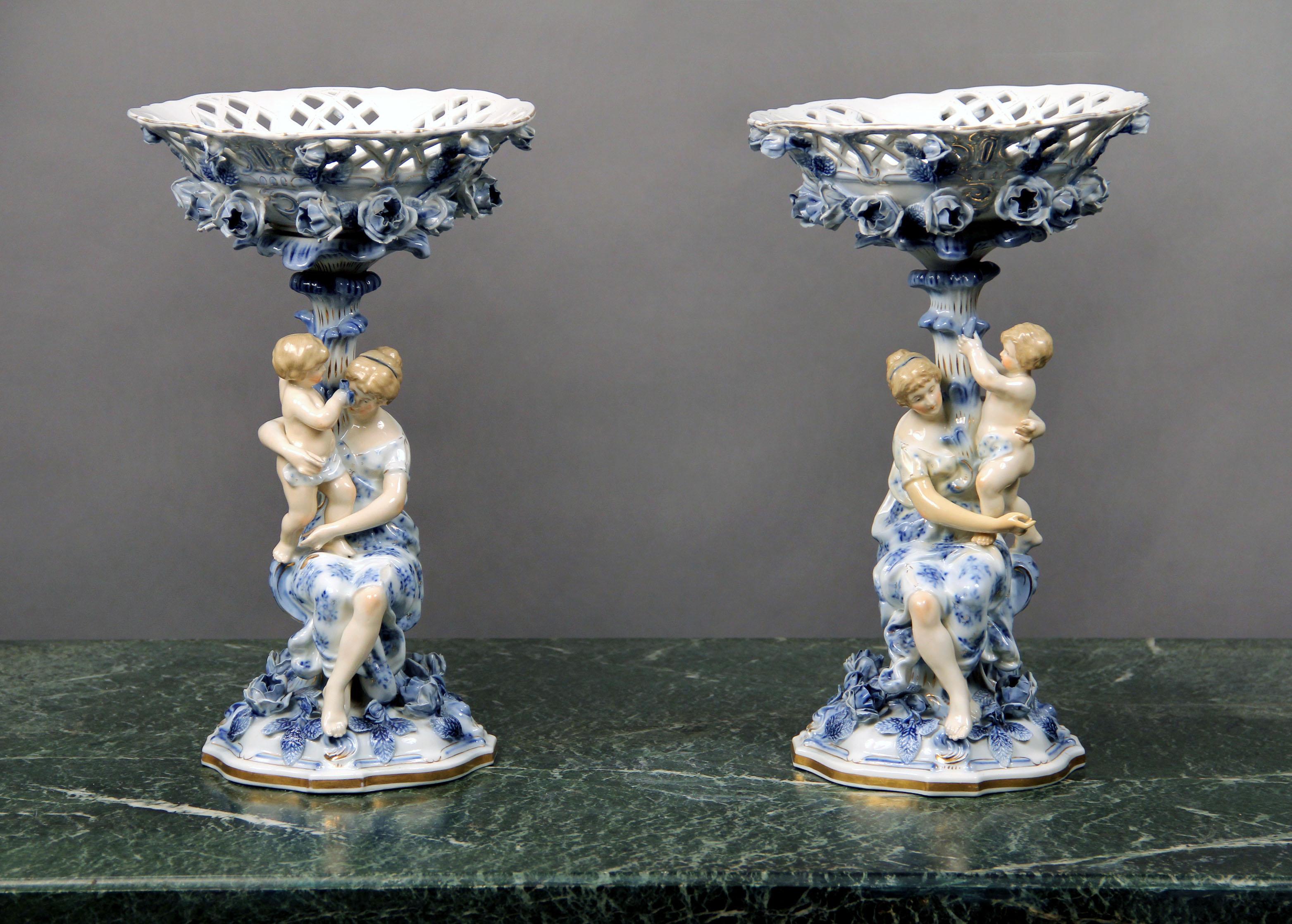 Pair of early 20th century continental porcelain compotes

In the “Blue Onion” pattern with pierced strapwork oval basket and supported by a flowering palm tree with mother and child.