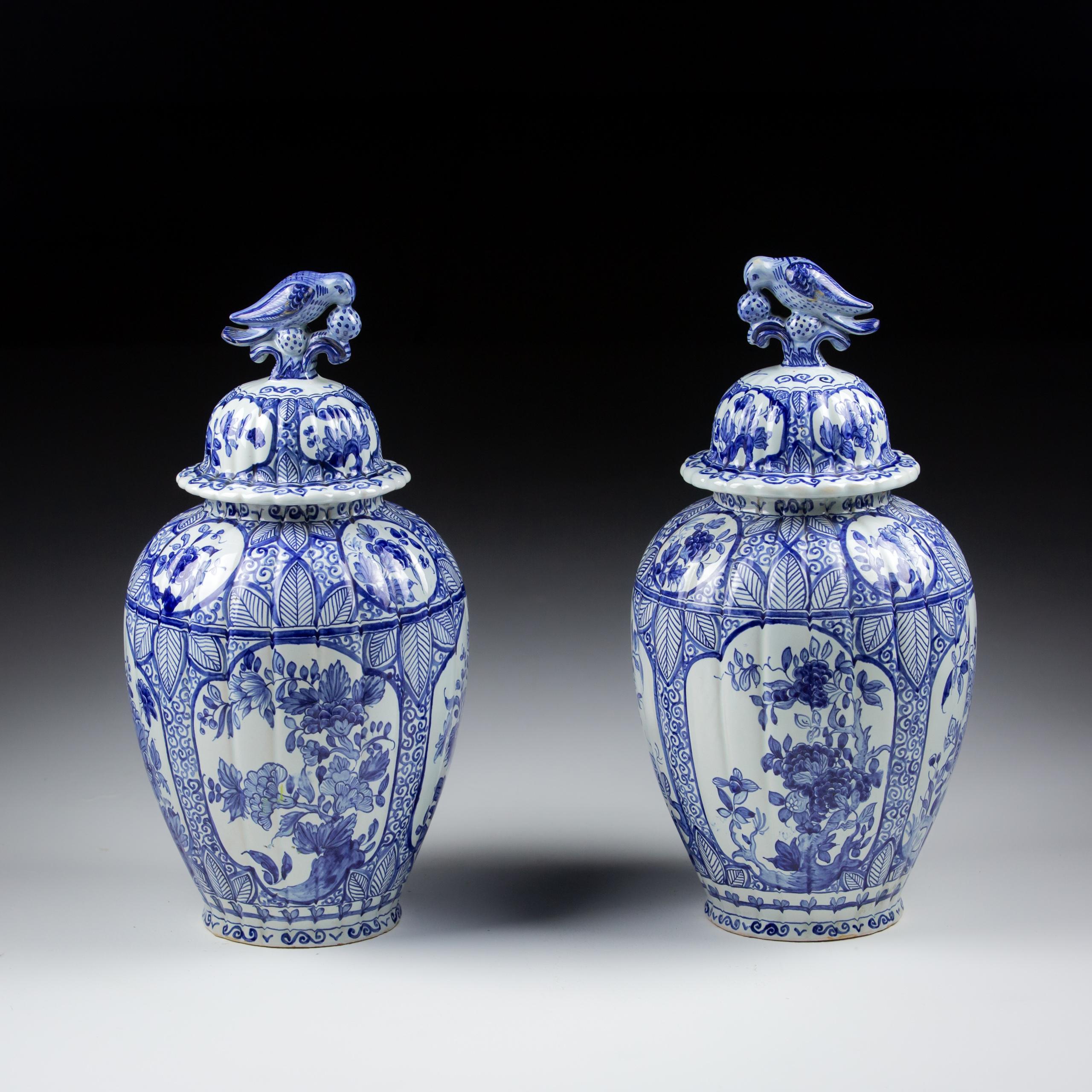 Pair of Early 20th Century Desvres Delft Covered Vase. Profusely decorated with bird finials to lids. One small Chip to rim of one vase France Circa 1920.