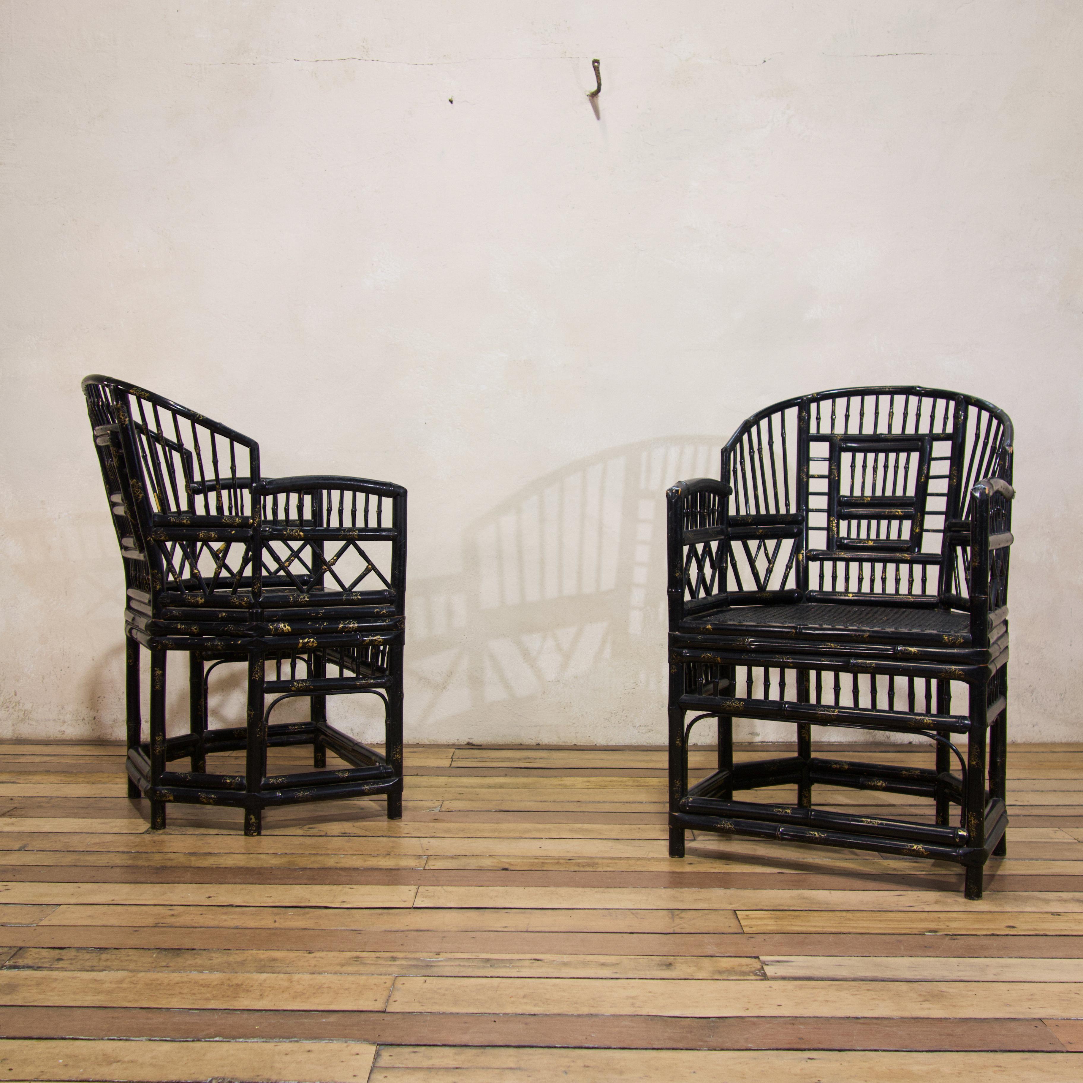 A pair of early 20th century ebonised and gilt decorated 'Brighton Pavilion' bamboo and caned armchairs. Displaying gracefully curved arms in a horseshoe shape, supported by geometric designs in a Chinese Chippendale style. Raised on six legs
