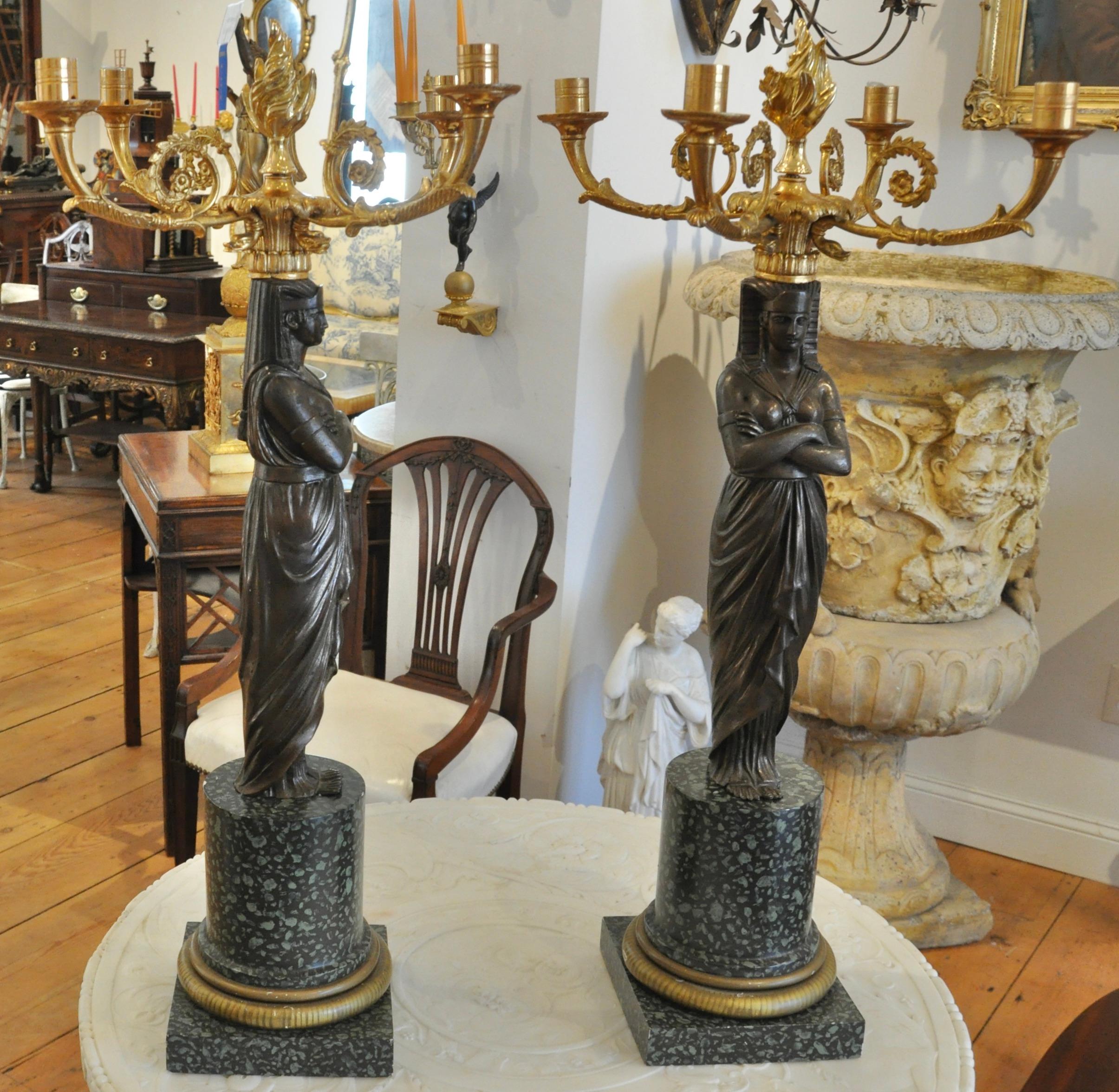 Pair of Early 20th century bronze, ormolu and wooden candelabra. Patinated Bronze Pharaoh Figures. Ormolu Candle arms. Wooden bases painted to resemble green Egyptian porphyry.
  