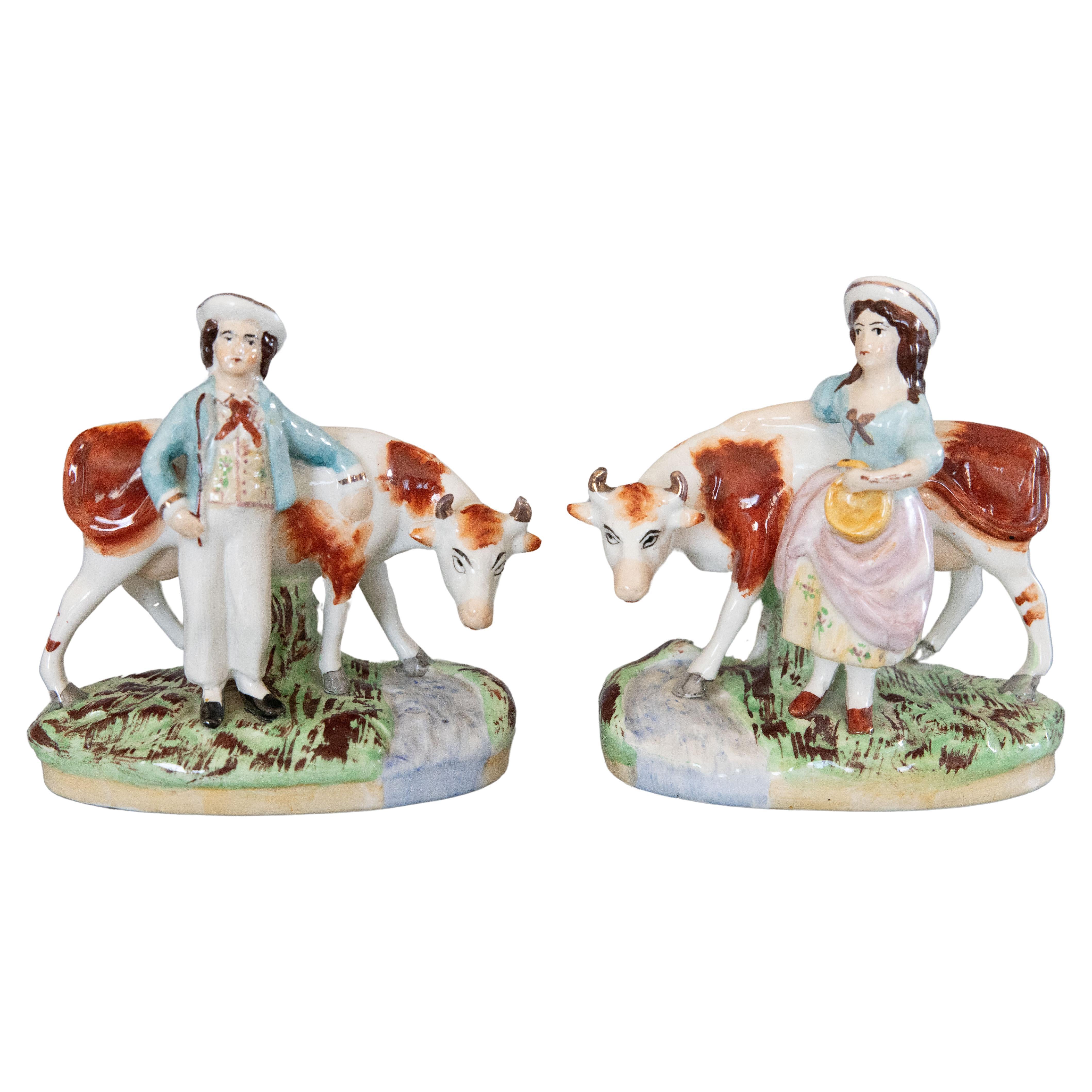 Pair of Early 20th Century English Staffordshire Boy & Girl Cow Figurines For Sale