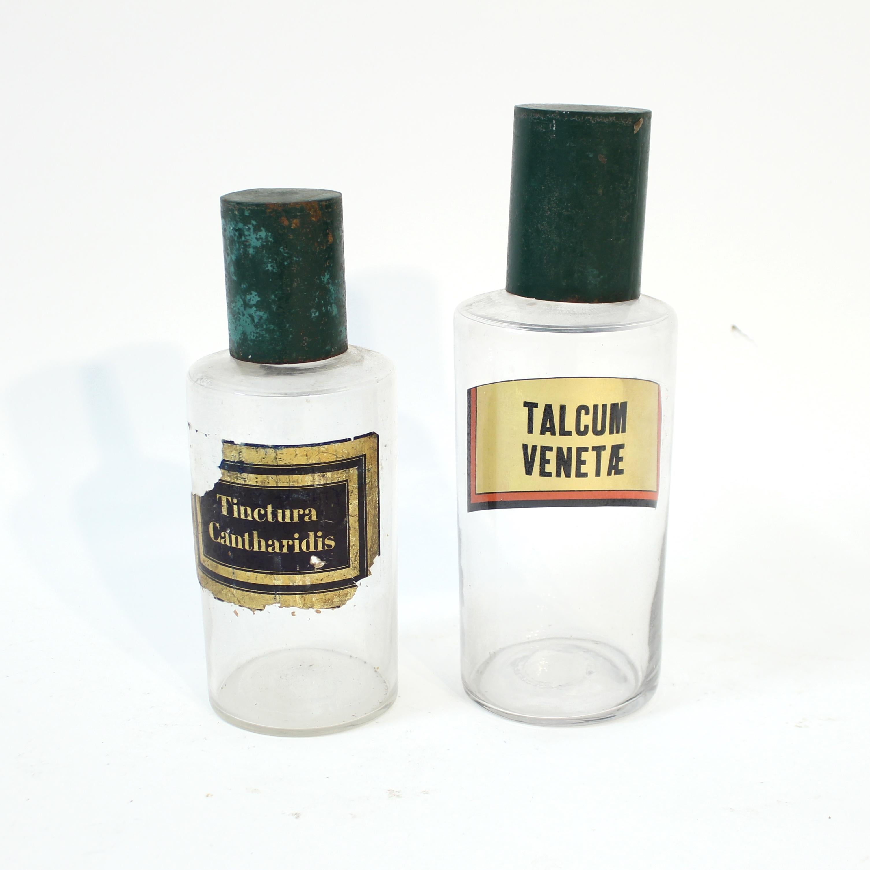 Pair of early, very decorative, 20th century French apothecary bottles from ca 1930s with green metal tops. Both with the original labels: 
