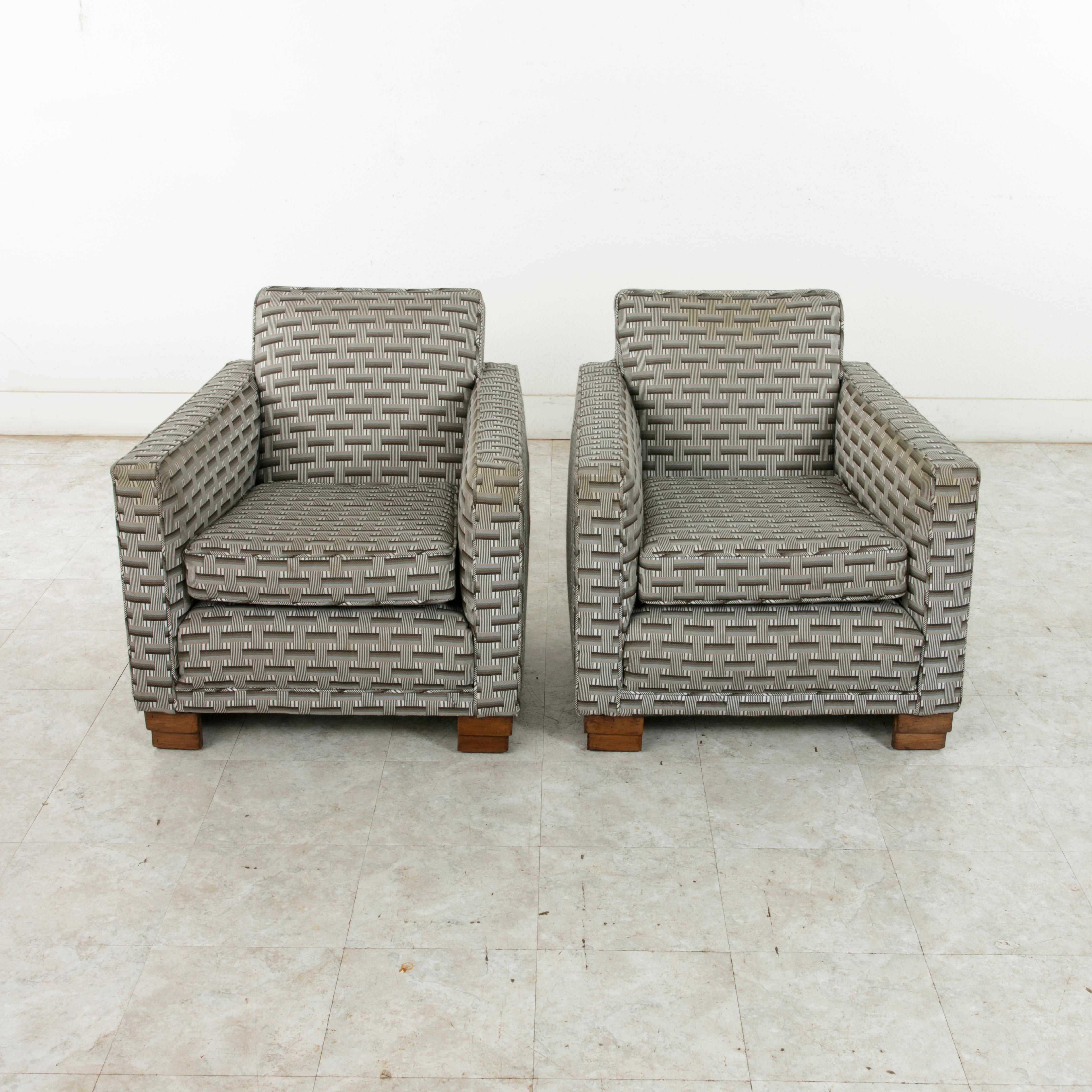 This pair of early 20th century French Art Deco period club chairs or lounge chairs features a grey geometric patterned upholstery, typical of the period. Resting on solid oak runner feet, this very comfortable pair boasts a wonderful scale to fit