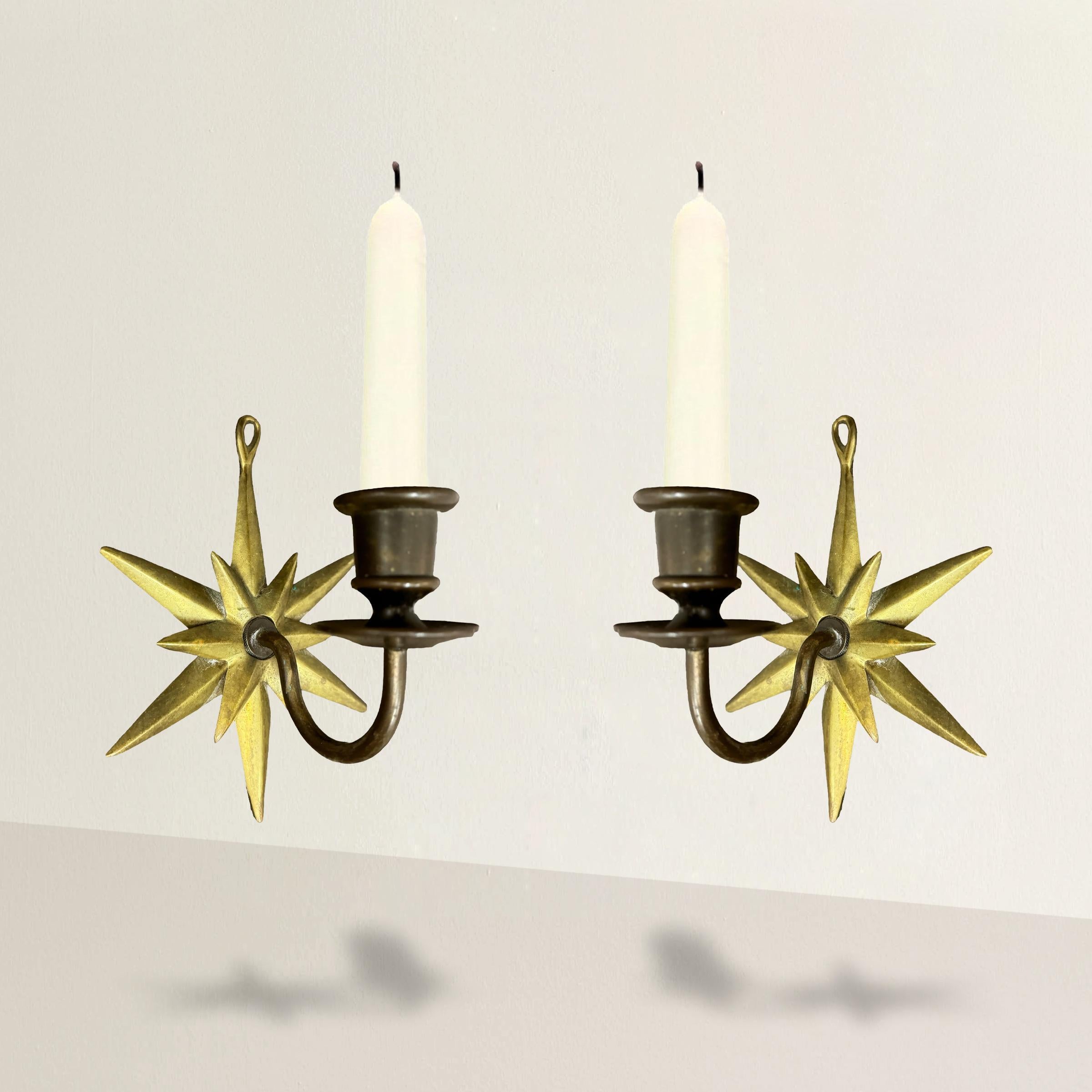 These early 20th-century French candle sconces are a stunning example of timeless elegance and craftsmanship. Featuring beautiful gold twelve-point star backplates and patinated bronze scrolled arms, these sconces exude sophistication and