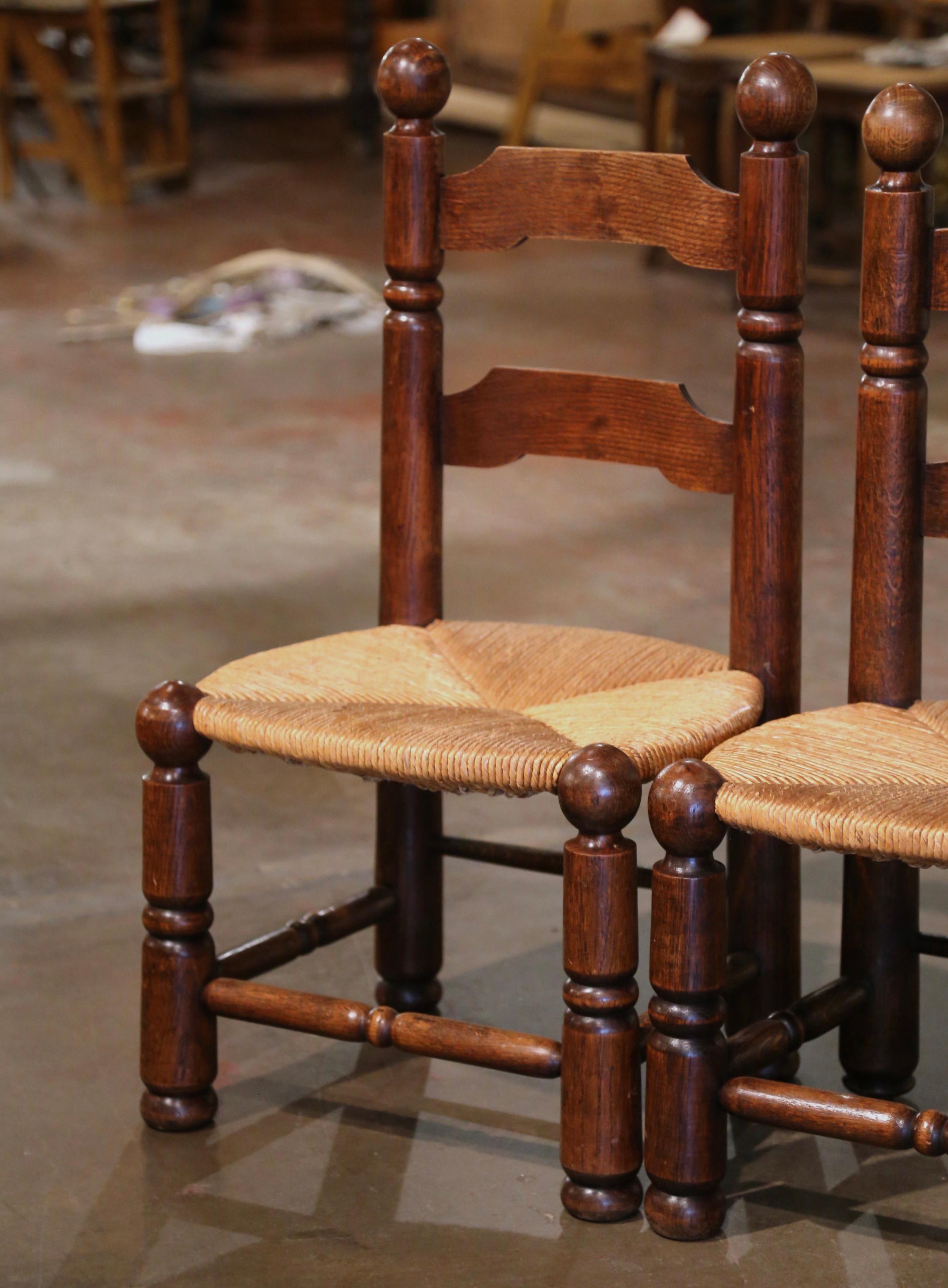 These very comfortable antique ladder back chairs were crafted in Normandy, France circa 1920. Built in walnut and beechwood and attributed to Charles Dudouyt, each chair sits on round turned legs and features two ladders in the back embellished