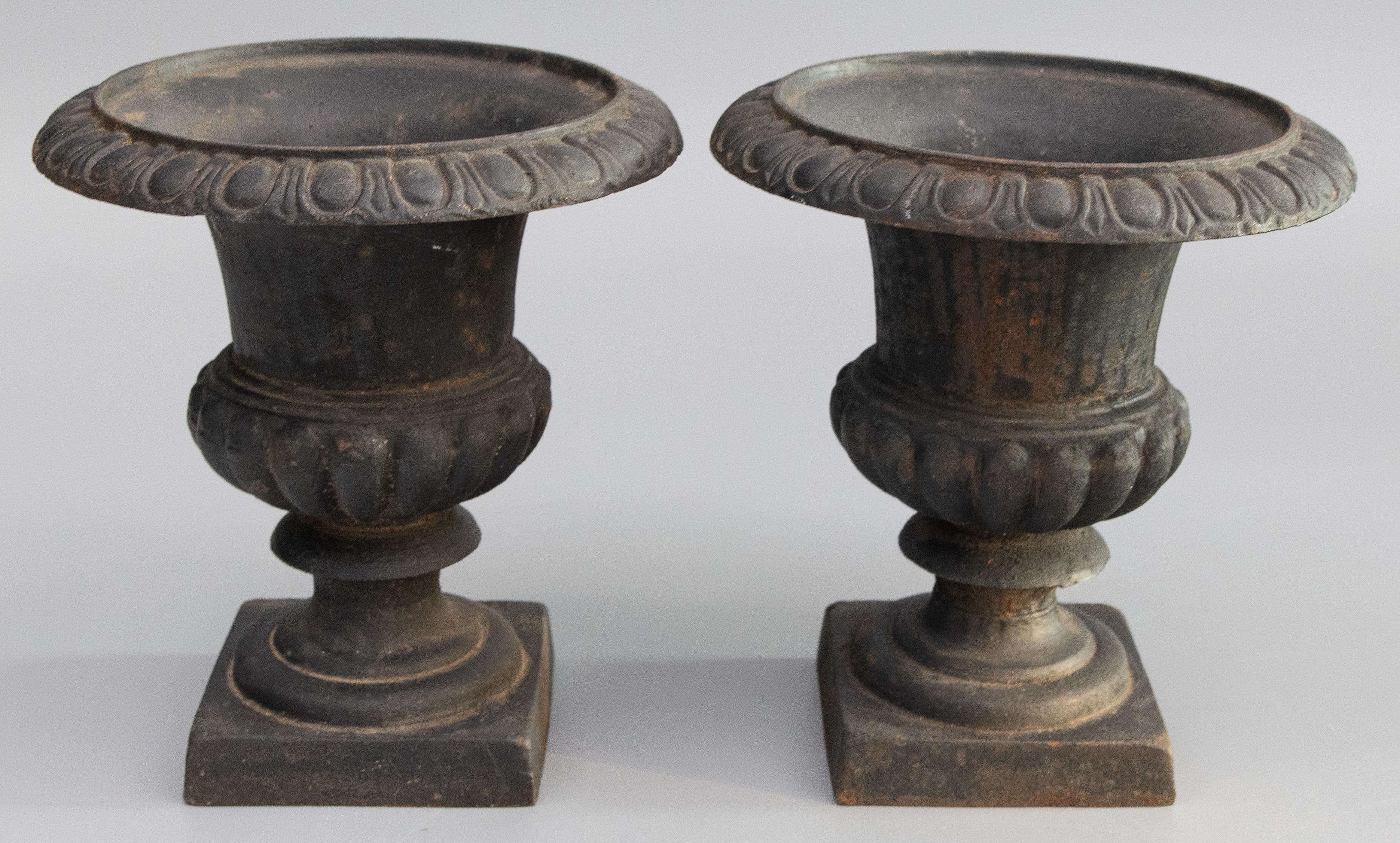 A fabulous pair of antique early 20th-Century French Neoclassical style cast iron mantel urns or planters. These urns are solid and heavy and retain their amazing original patina. They would be lovely displayed indoors or outdoors.

DIMENSIONS
9ʺW ×