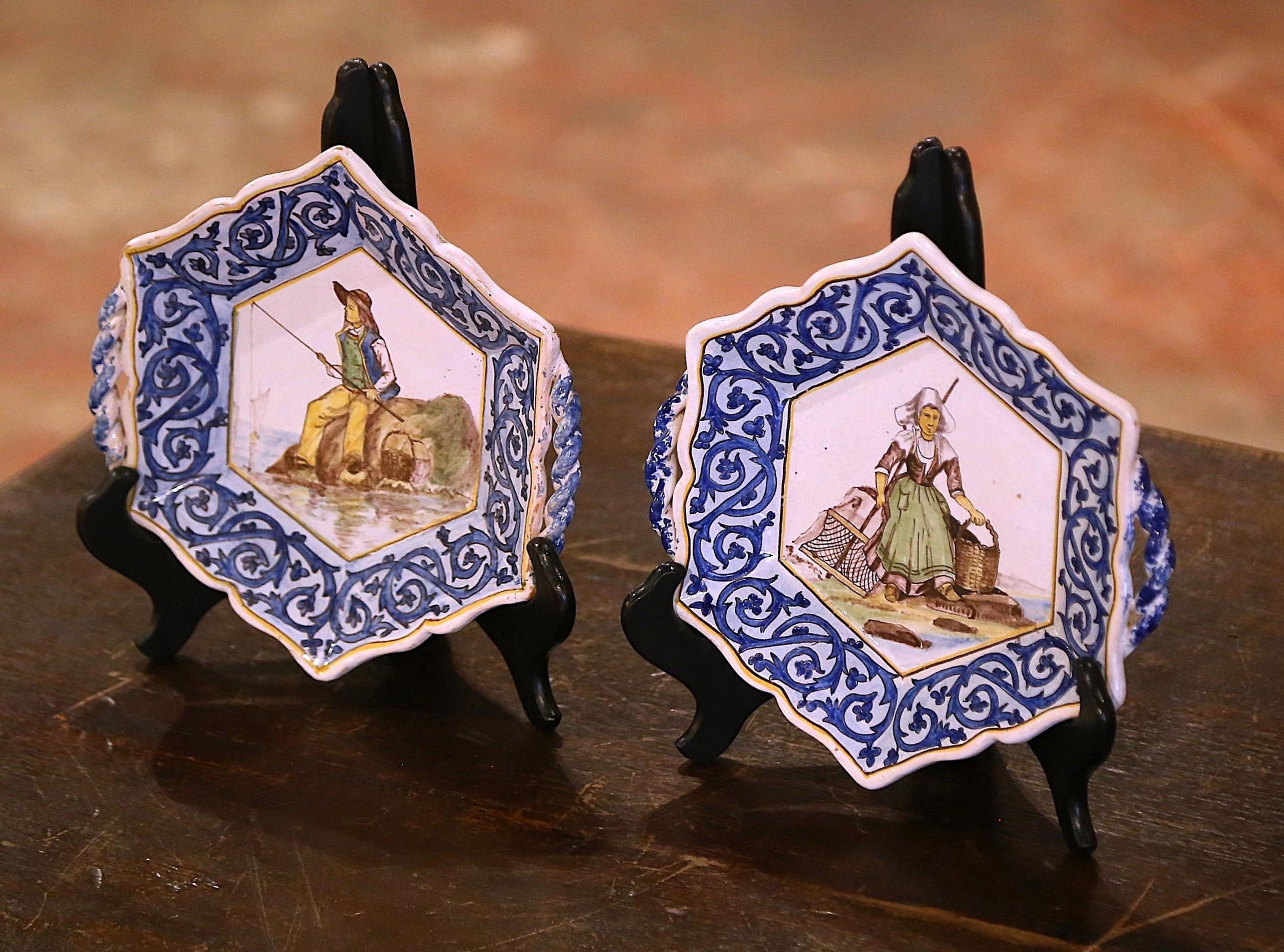 Decora una mesa de centro o una estantería con este elegante par de platos antiguos. Creadas en Bretaña, Francia, hacia 1910, y firmadas por De La Haubardiere Quimper, las bandejas de forma hexagonal pintadas a mano están aderezadas con asas