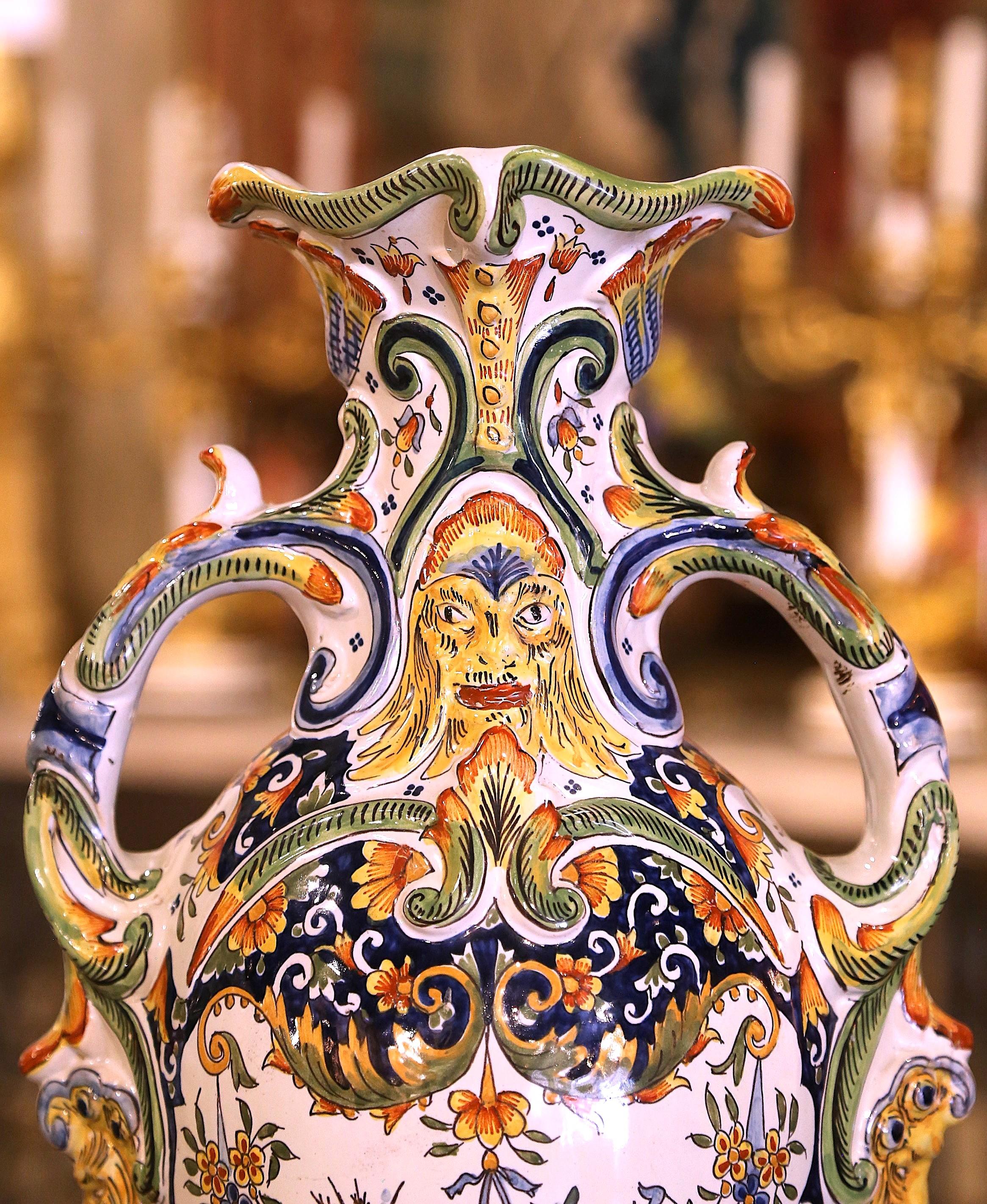 Impreziosisci il tuo caminetto o il tuo tavolo con questa straordinaria coppia di vasi antichi in maiolica. Realizzato in Francia, in Normandia, intorno al 1920, ogni vaso alto poggia elegantemente su una base rotonda, con grandi manici laterali a