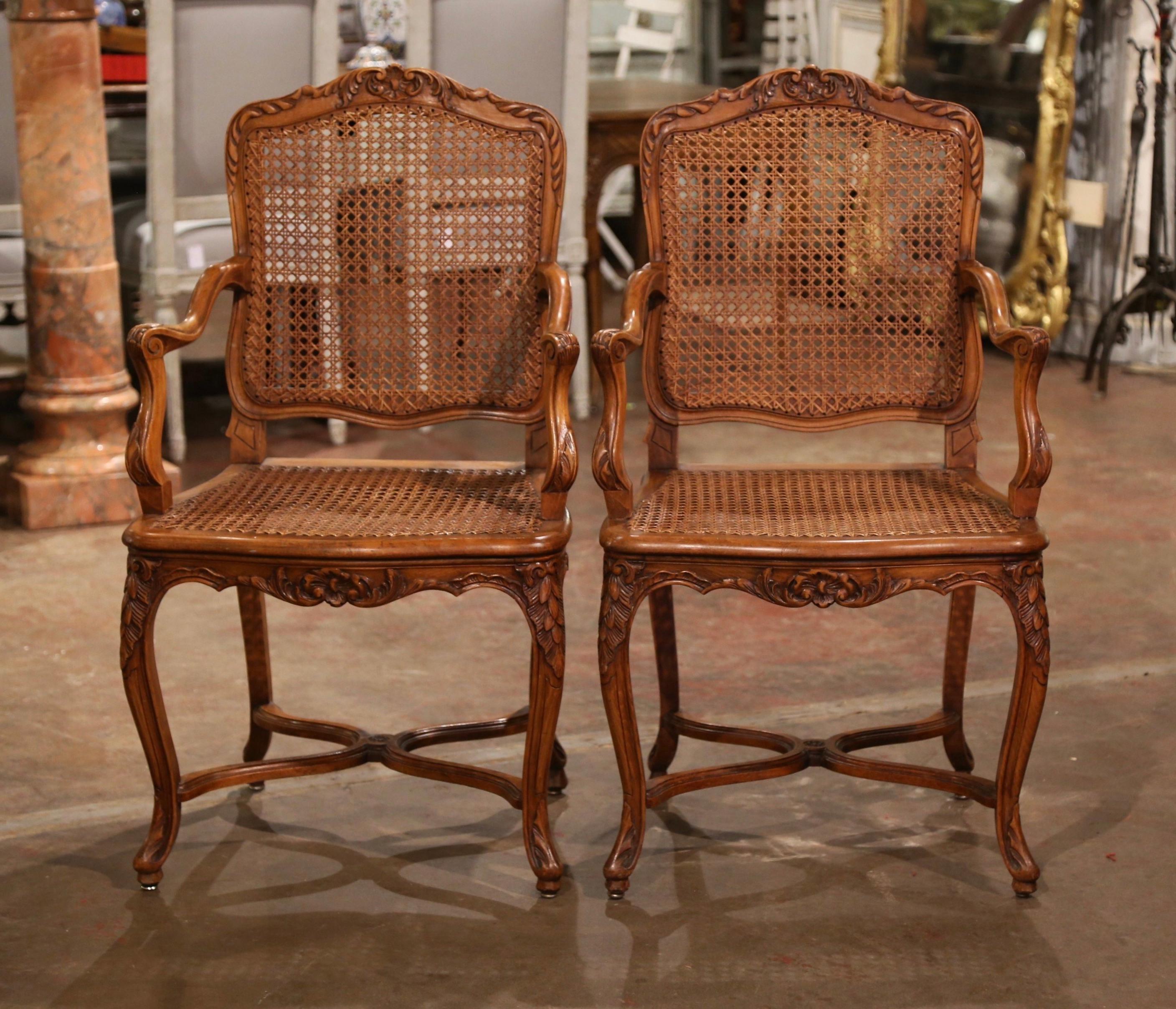 Decorate a study or office with this elegant pair of antique armchairs. Crafted in Provence, France, circa 1920, each chair stands on cabriole legs decorated with leaf motifs at the shoulders, and ending with scroll feet over a decorative X