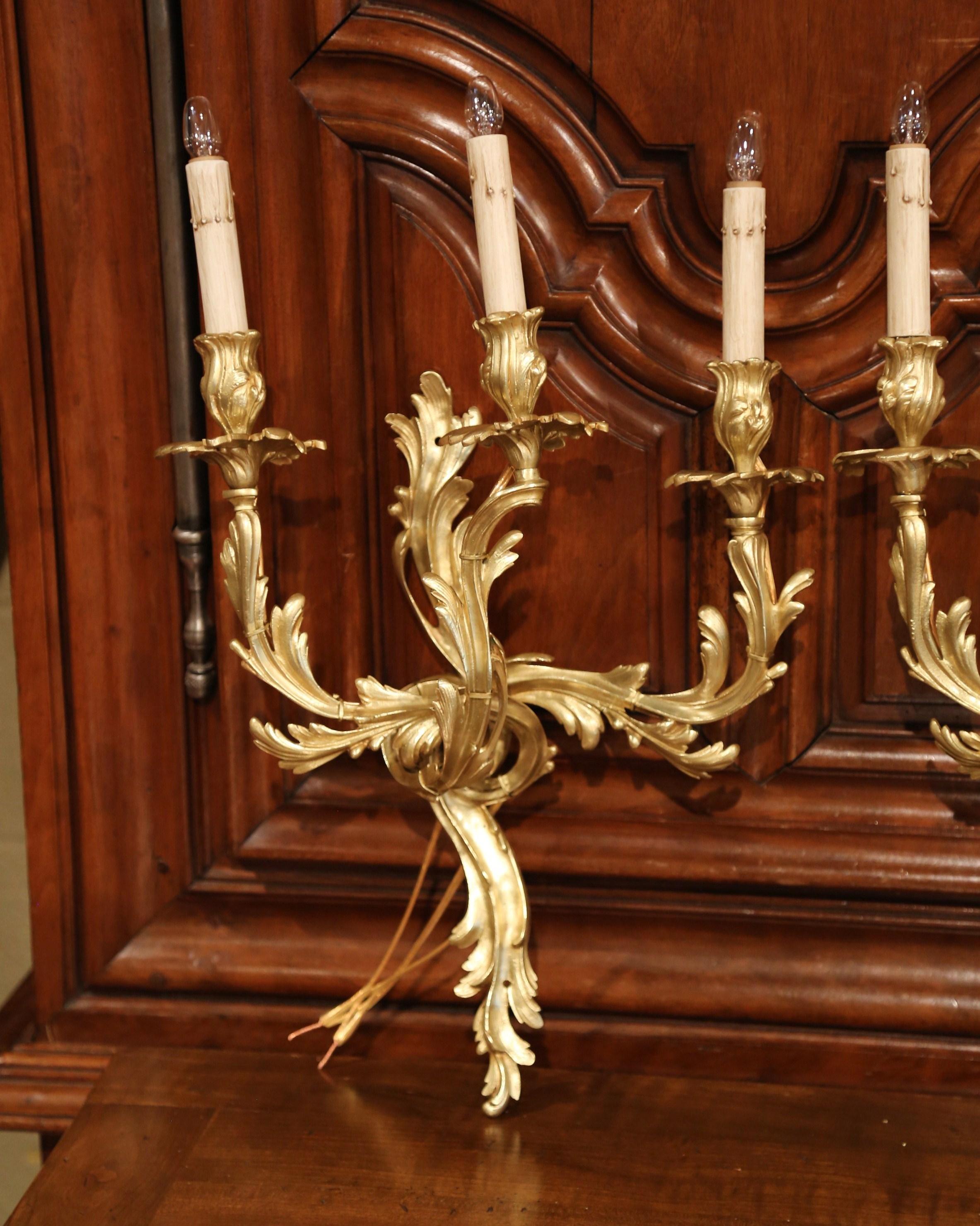 This elegant pair of antique bronze sconces was crafted in France, circa 1920. Each of the ornate sconces has three lights newly wired and features scroll design with decorative foliage decor. The delicate, traditional light fixtures are in