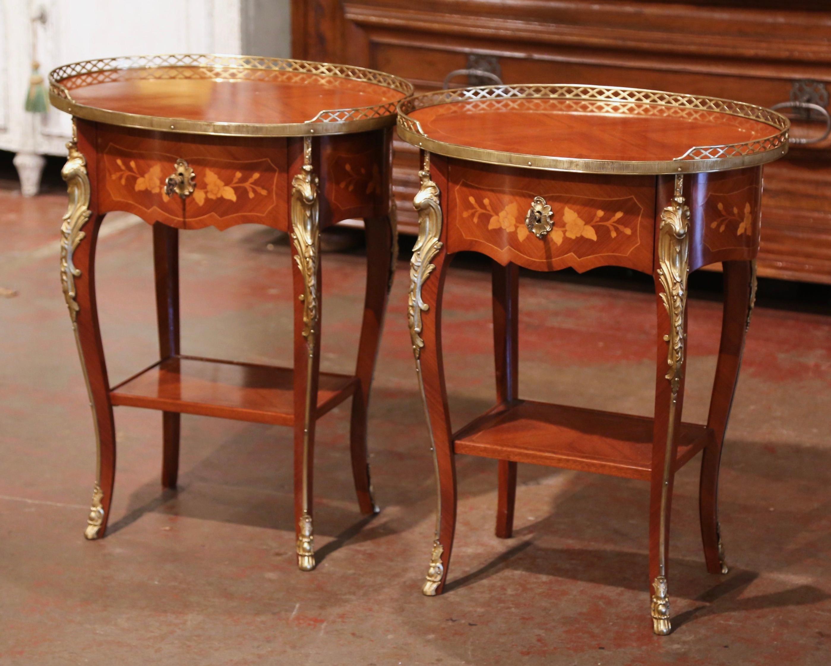 Crafted in France circa 1920, the elegant antique tables stand on cabriole legs decorated with acanthus leaf mounts at the shoulder, ending with sabot feet over a bottom shelf with raised edges. Each occasional table features detailed inlaid