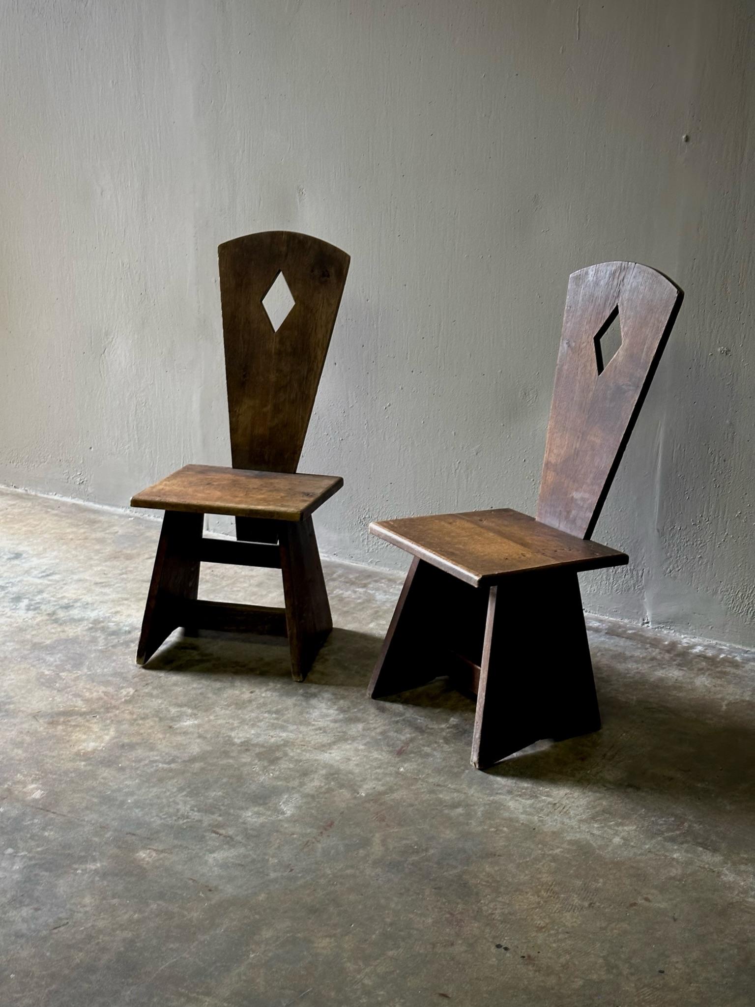 Zwei hübsche französische Stühle aus massiver Eiche mit rustikalem und doch modernem Profil aus dem frühen 20. Mit ihrer elementaren, handgefertigten Qualität und ihrer streng geometrischen Silhouette ist das Paar eine Lektion in Sachen