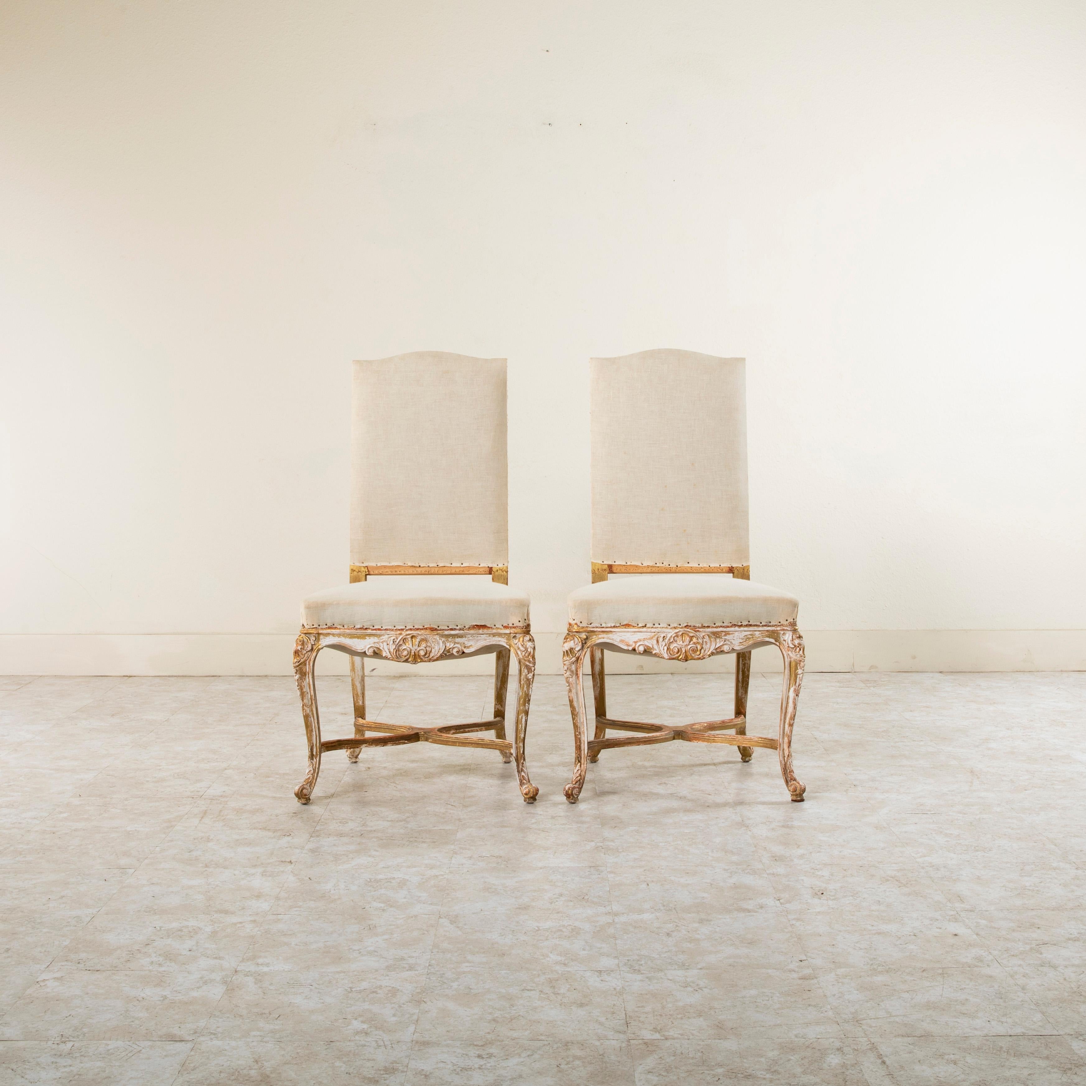 Dieses Paar bemalter französischer Beistellstühle im Regency-Stil aus der Jahrhundertwende zeichnet sich durch symmetrisch handgeschnitzte Mittelschalen aus, die von gadronierten Akanthusblättern an den Fronten und Seiten flankiert werden.