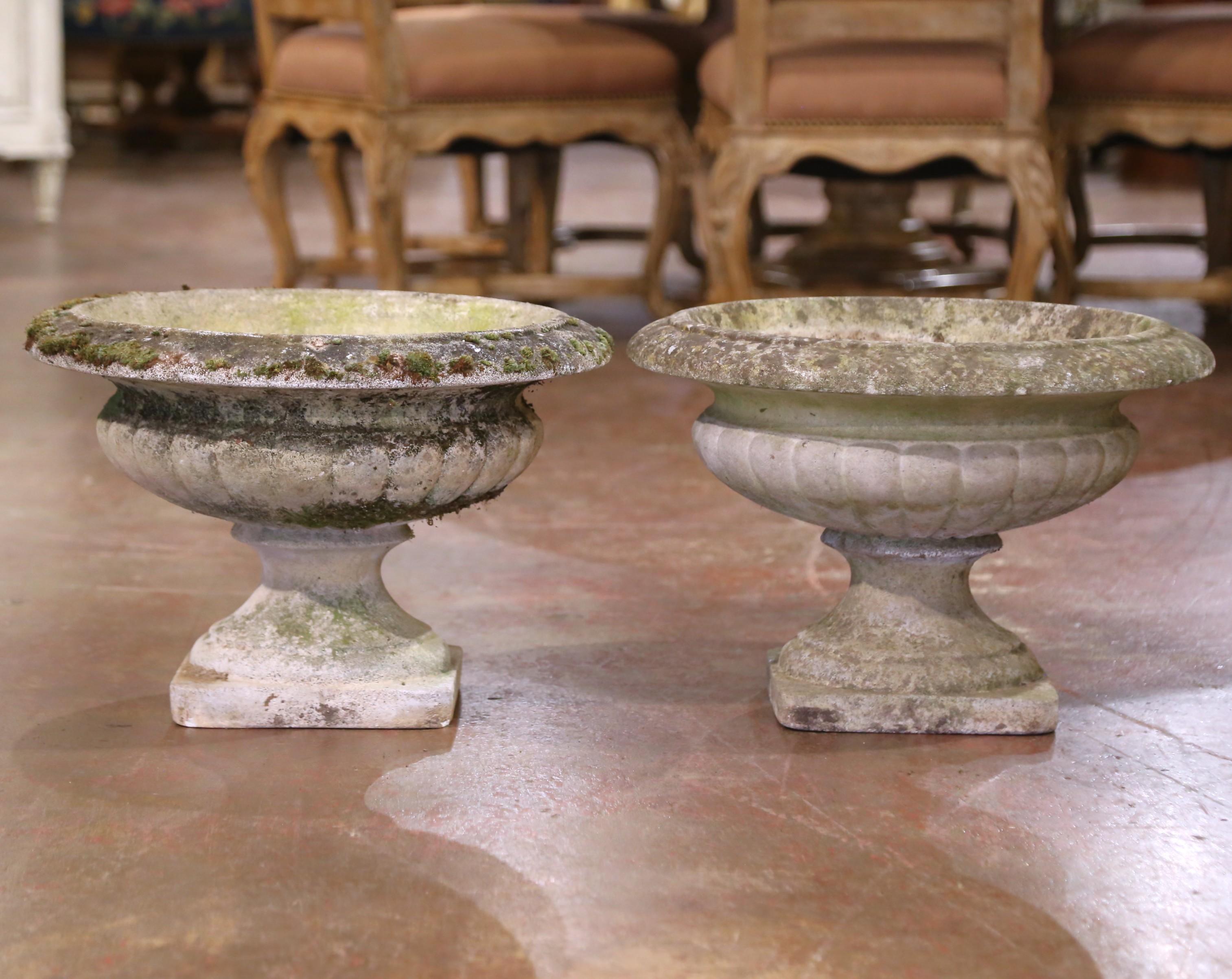 Decorate a garden, backyard, or poolside area with this elegant pair of antique planters. Created in France circa 1920 by Grandon Frères, each cast stone urn is signed with the maker’s round medallion reading “Grandon Fcs – Made in France –