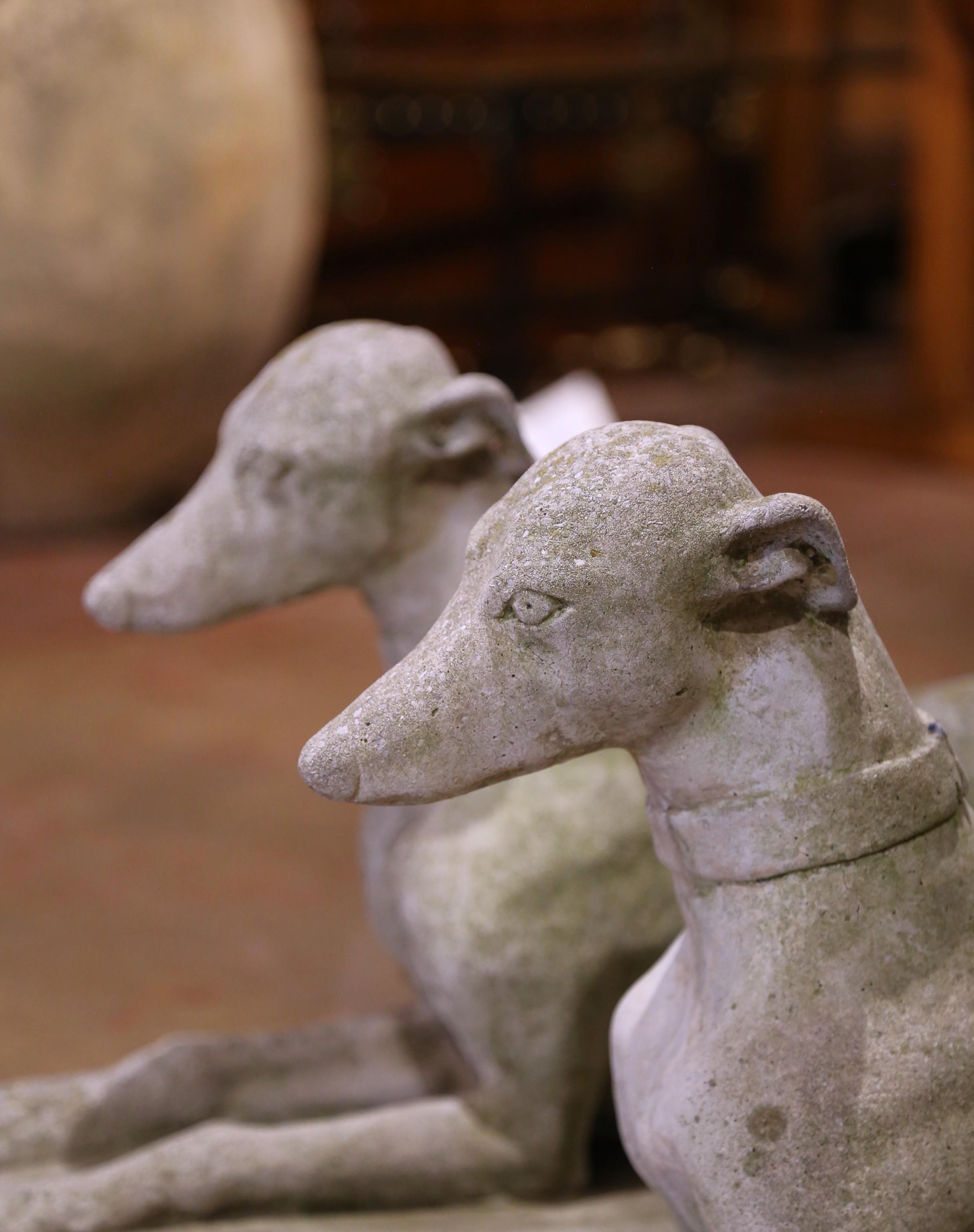Français Paire de sculptures de chien en pierre moulée patinée par les intempéries, datant du début du 20e siècle.