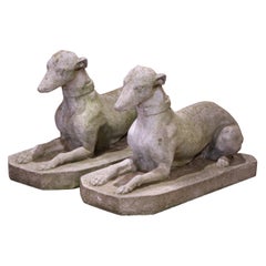 Paire de sculptures de chien en pierre moulée patinée par les intempéries, datant du début du 20e siècle.